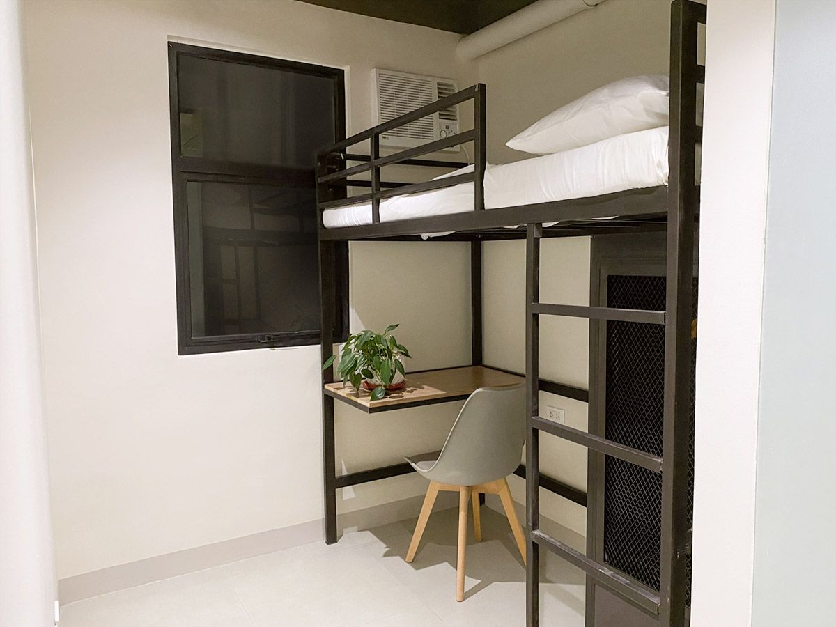 Loft bed with built-in desk and chair at The Grid Co-Living Makati dorm
