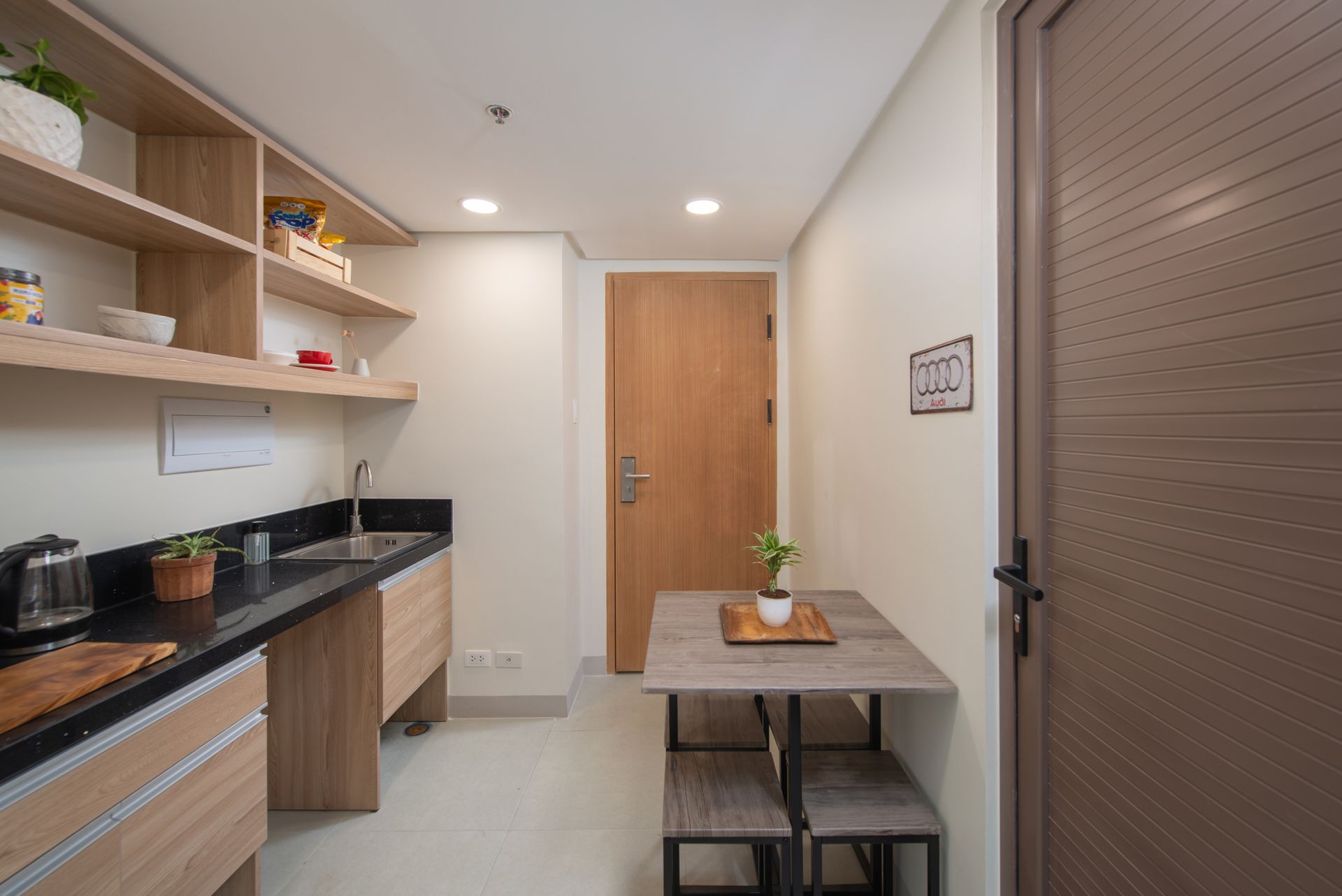 The Grid in Makati: A kitchen with a table and stools and a door