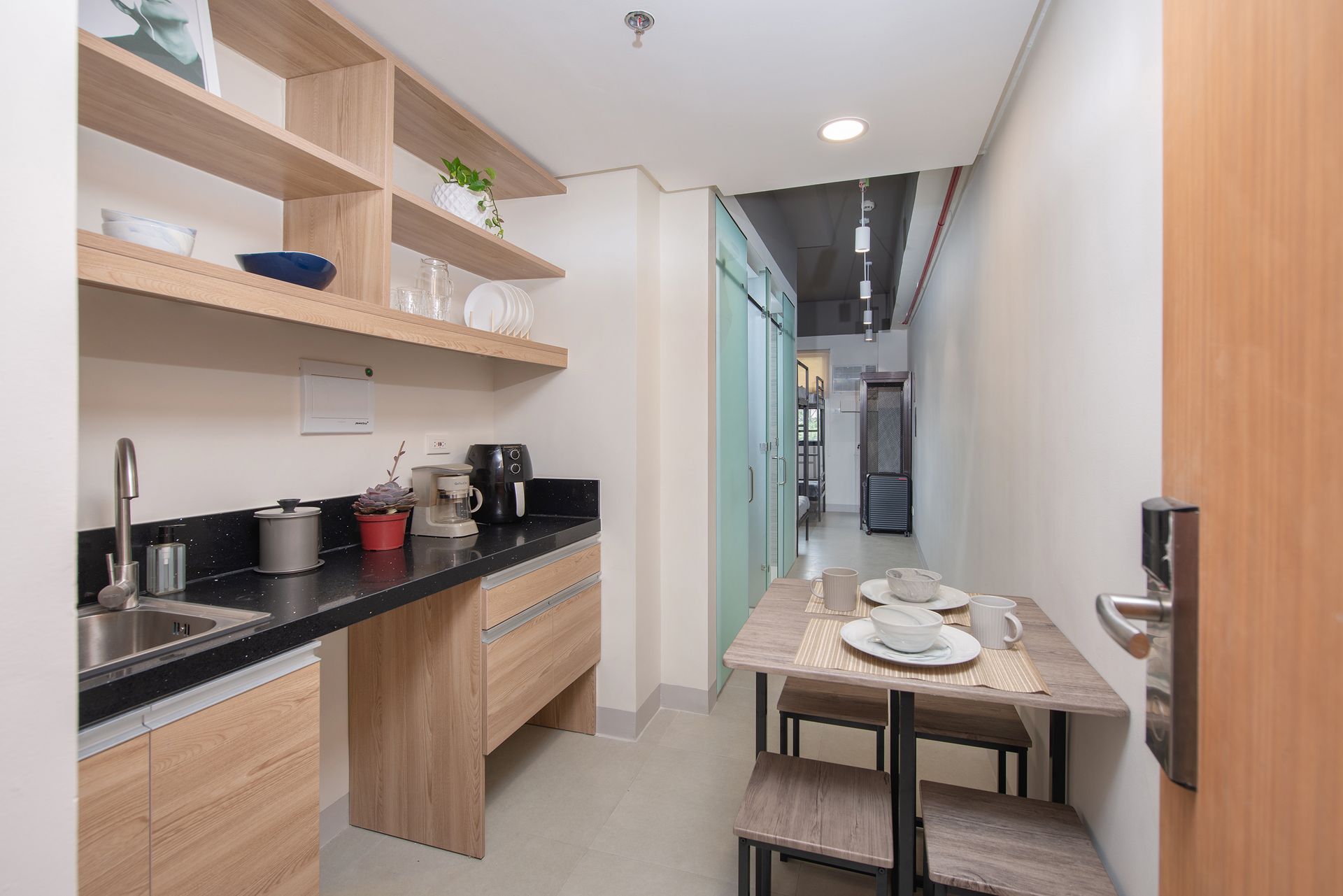 The Grid Makati: With a kitchen,  table and chairs and a sink.