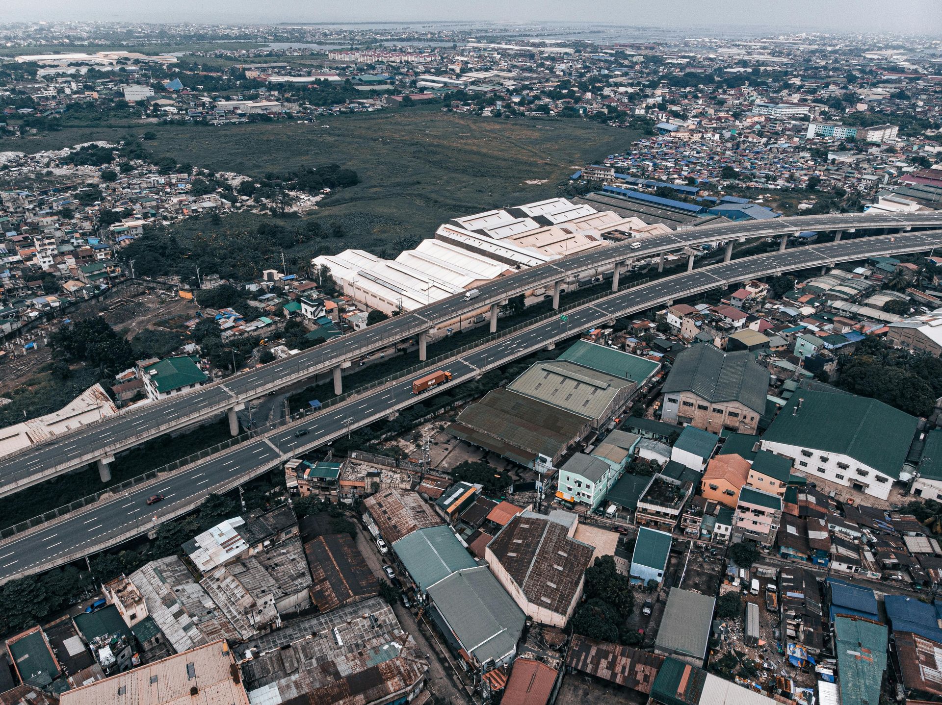 Aerial view of elevated expressway near Makati CBD with dense urban surroun