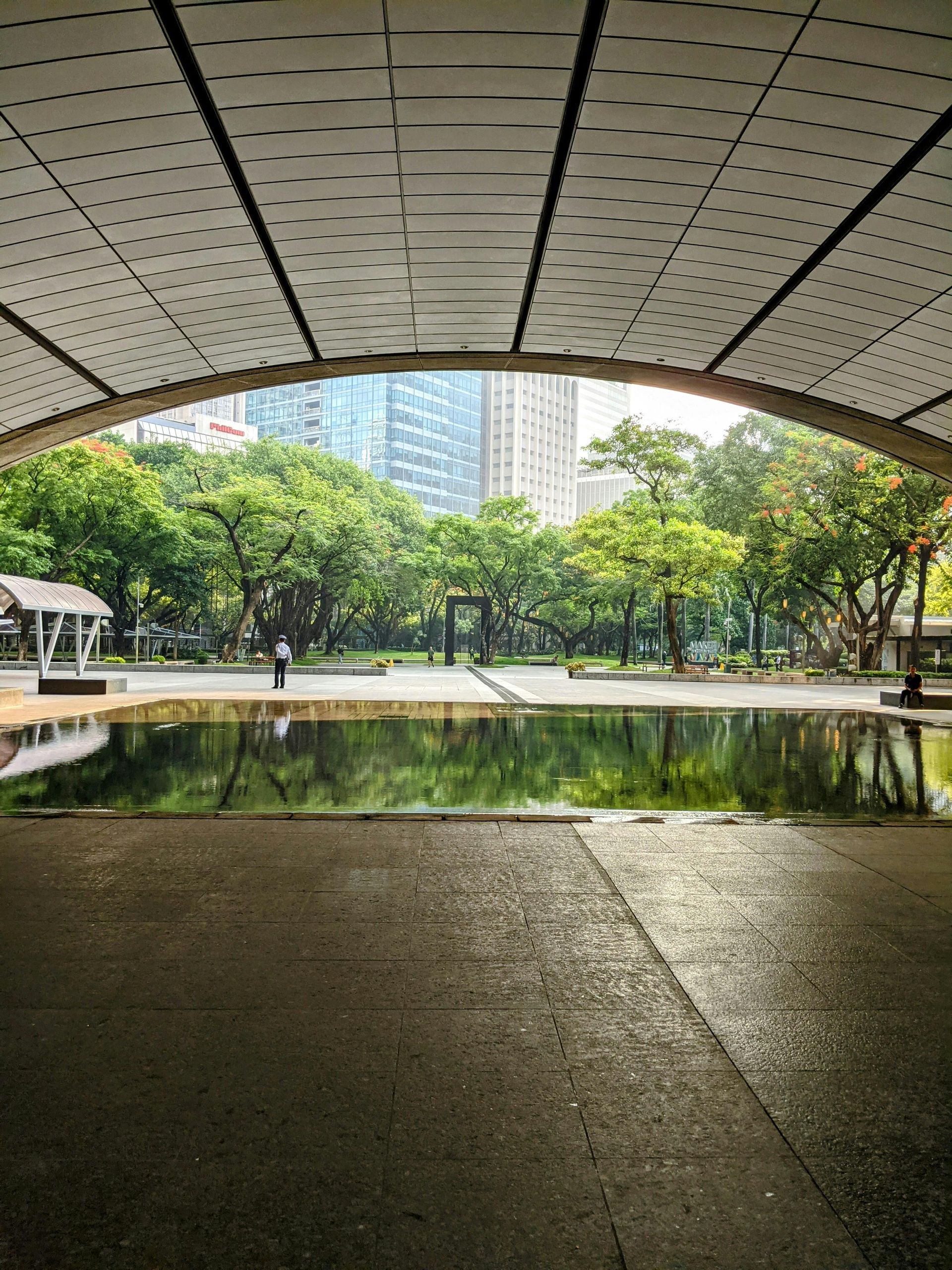 Scenic park view with reflection pool near Makati CBD skyscrapers