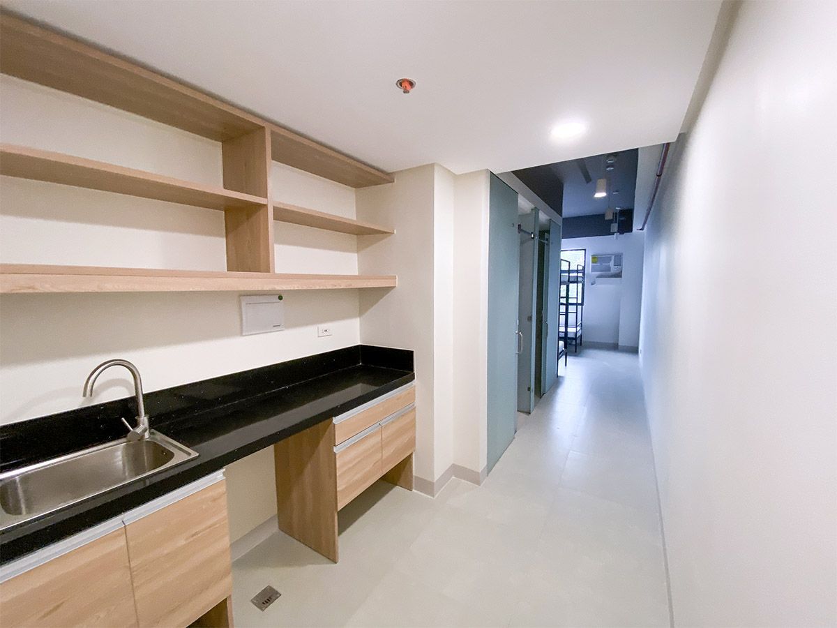 The Grid in Makati: A kitchen with a sink and shelves in a hallway.