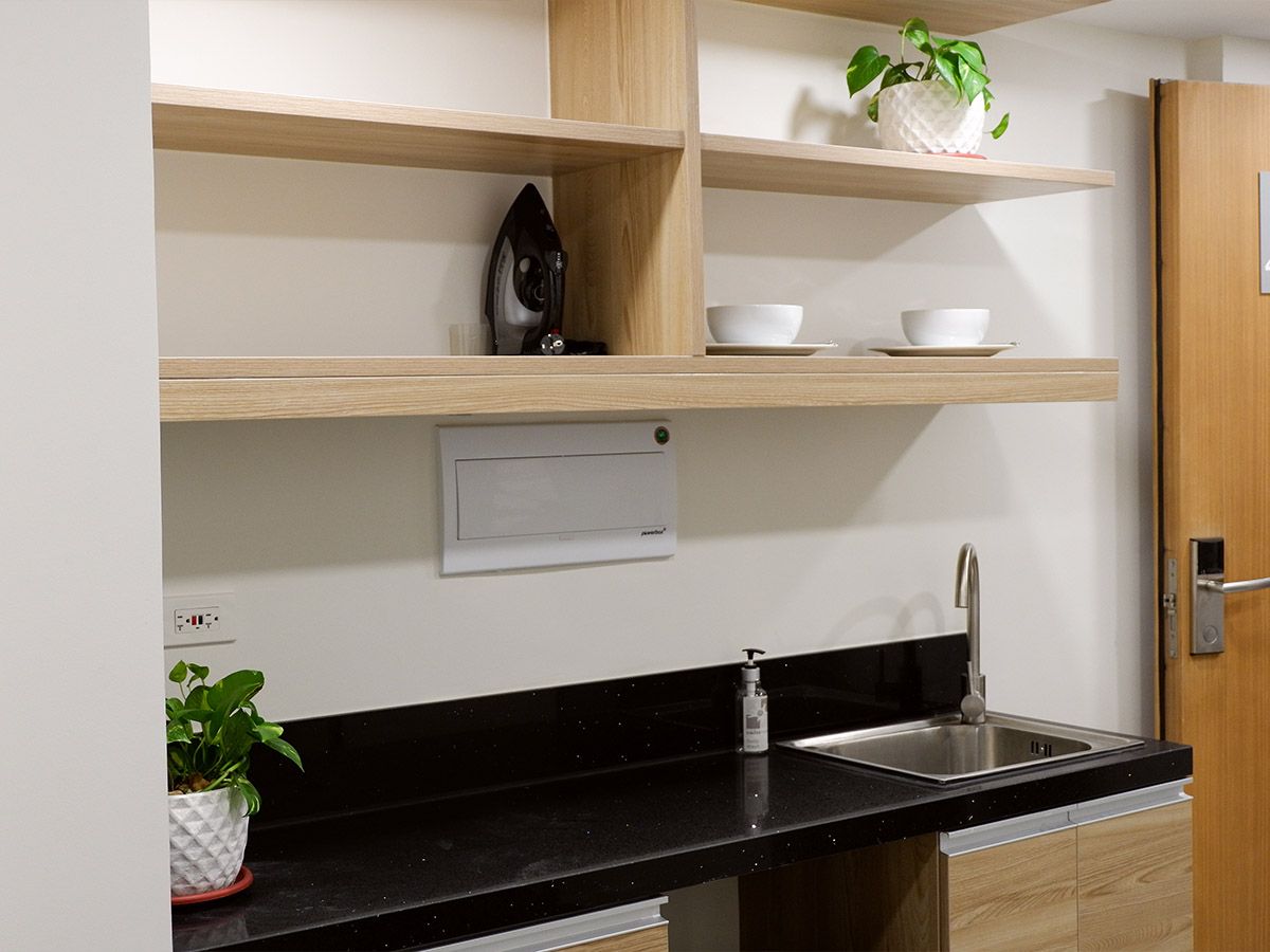 The Grid Makati: A kitchen with a sink , shelves , and a door.