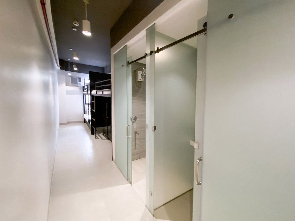 The Grid Makati: A hallway with sliding glass doors leading to a bathroom