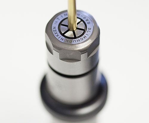 Close-up of a silver lock cylinder with a key inserted and turned at the top.