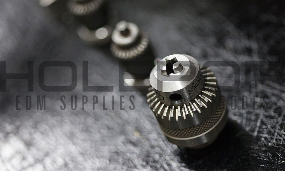 Metal watch gears and components on a dark surface with faint “Hollow Oak” branding in the background