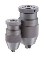 Close-up of a metal microphone with textured grip and engraved lettering, softly lit against a dark background