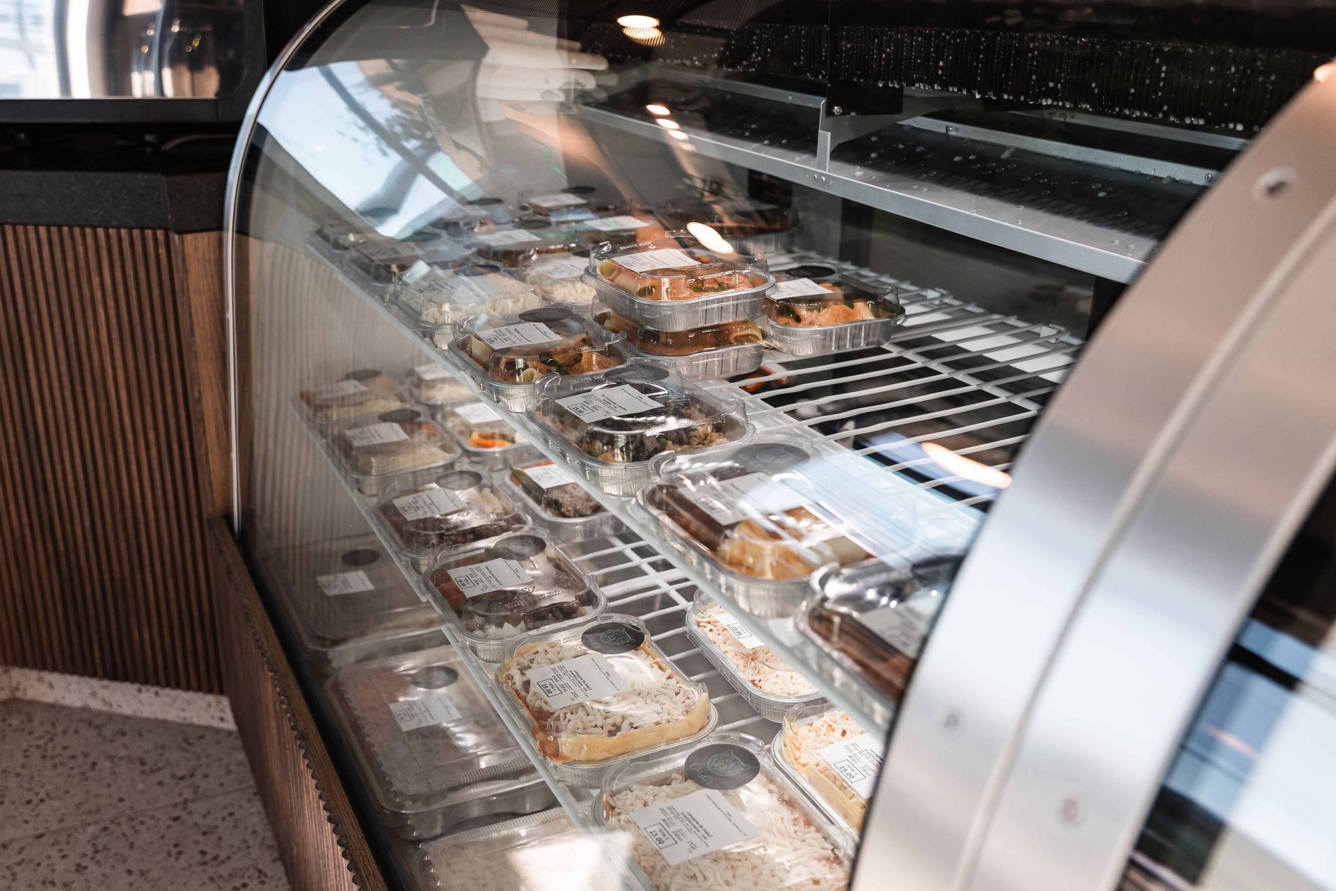 Vitrine remplie de produits de boulangerie emballés, dans un décor de café.