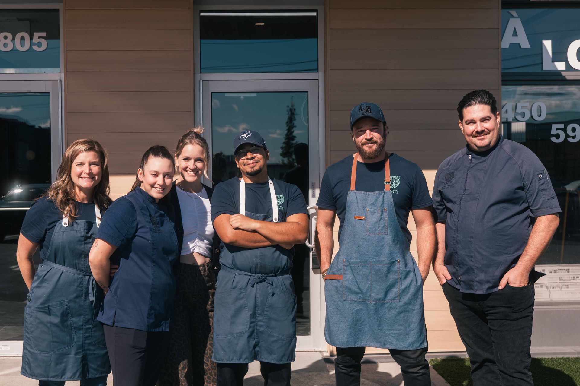 Le personnel du restaurant pose pour une photo devant son établissement.