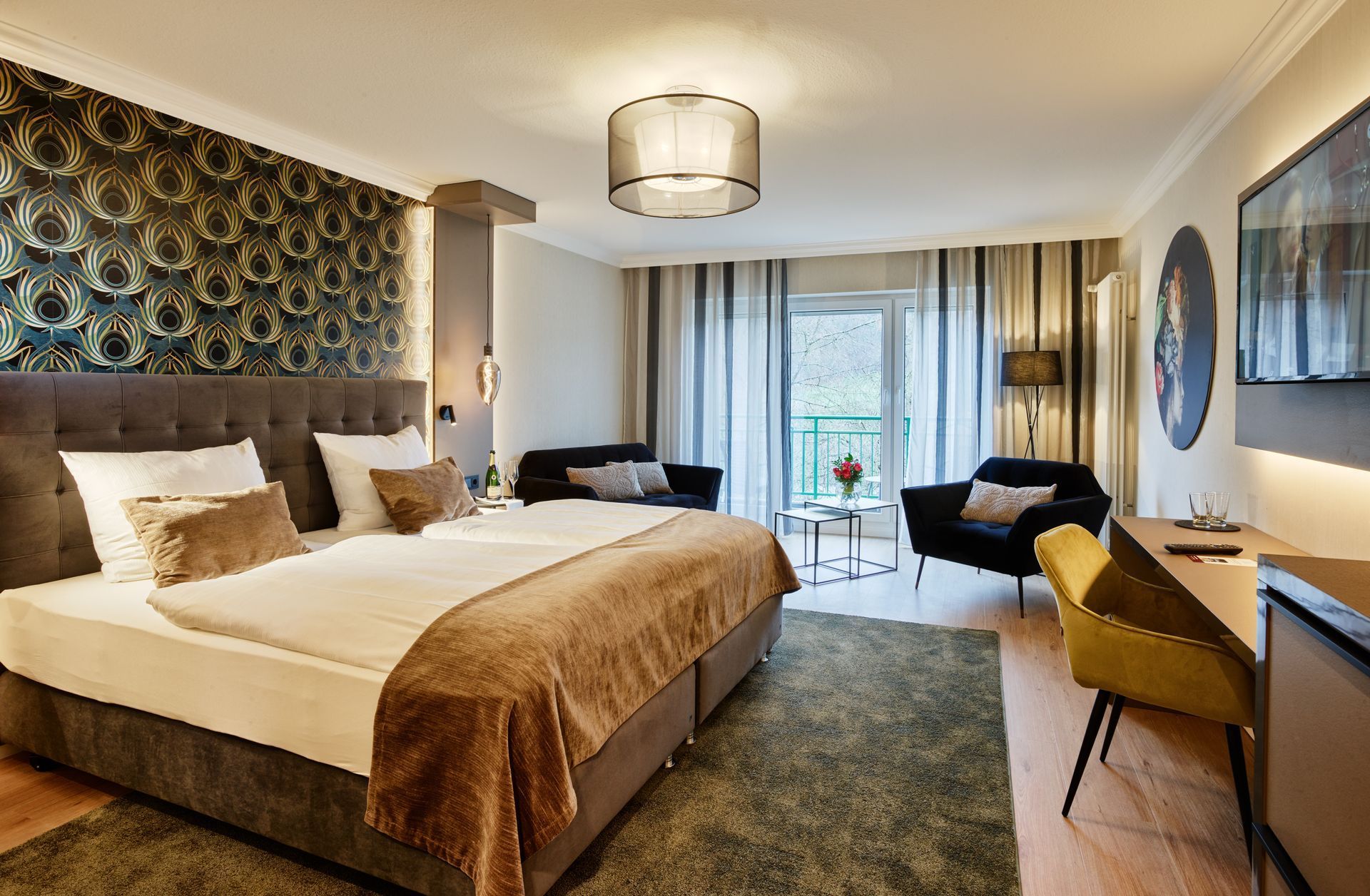 Modernes Hotelzimmer mit großem Bett, Sitzecke, Schreibtisch und Fensterblick auf die Stadtlandschaft