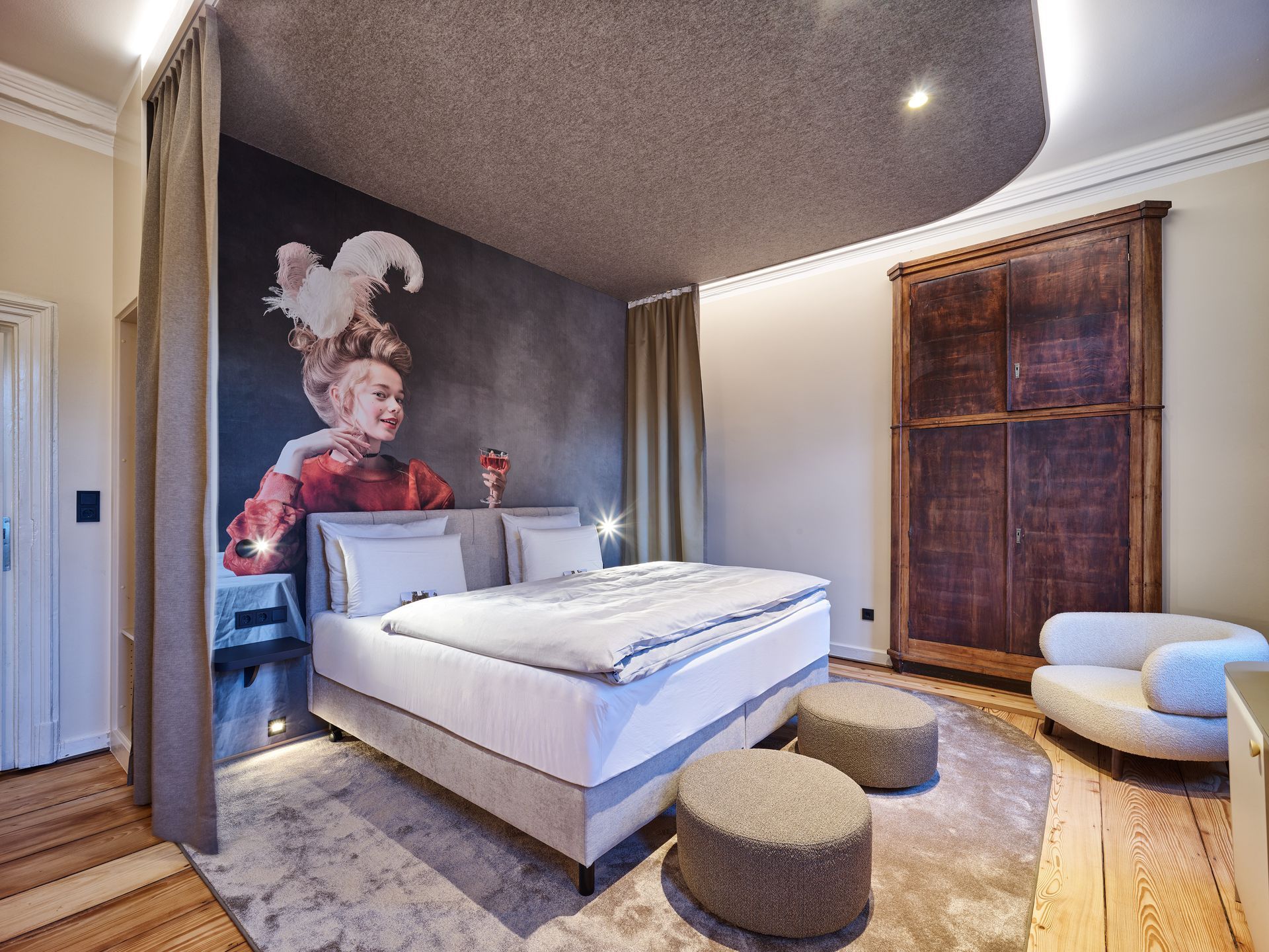 Modernes Schlafzimmer mit grauen Wänden, weißem Bett, Wandmalerei und einem großen Fenster mit Vorhängen.