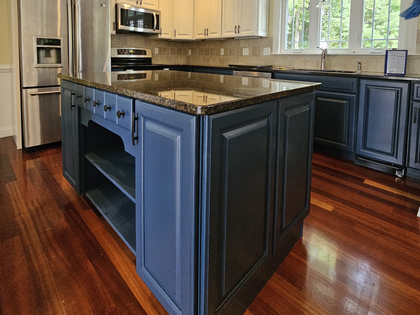 Modern kitchen with blue island, granite countertop, stainless appliances, and hardwood floors