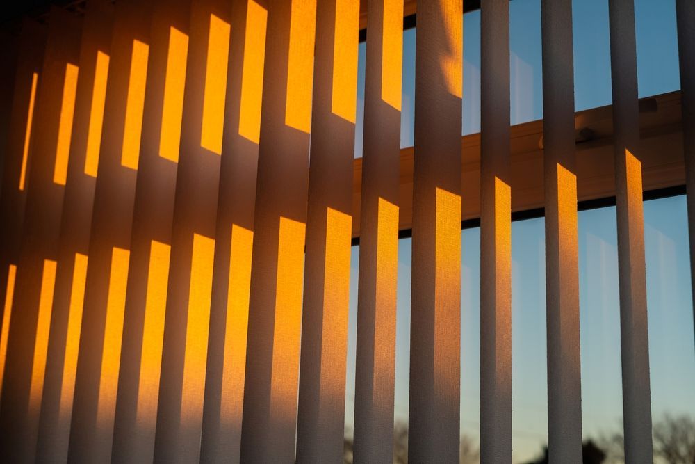 The Sun is Shining Through the Blinds and Casting a Shadow on the Wall — Curtain Haven & Blinds in Lake Cathie, NSW