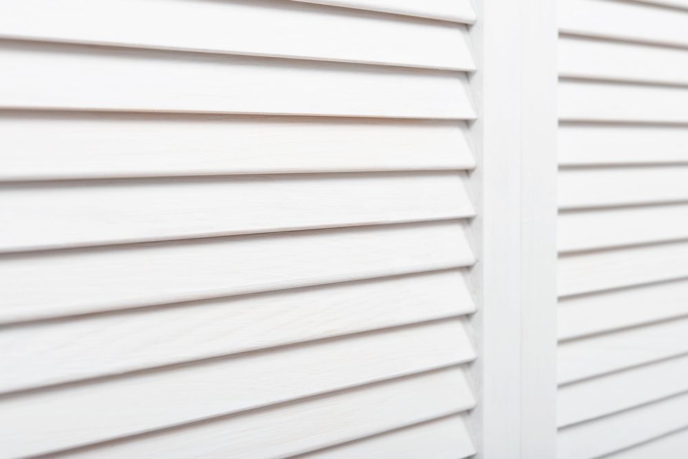 A Close Up of a Pair of White Shutters on a Wall — Curtain Haven & Blinds in Wauchope, NSW