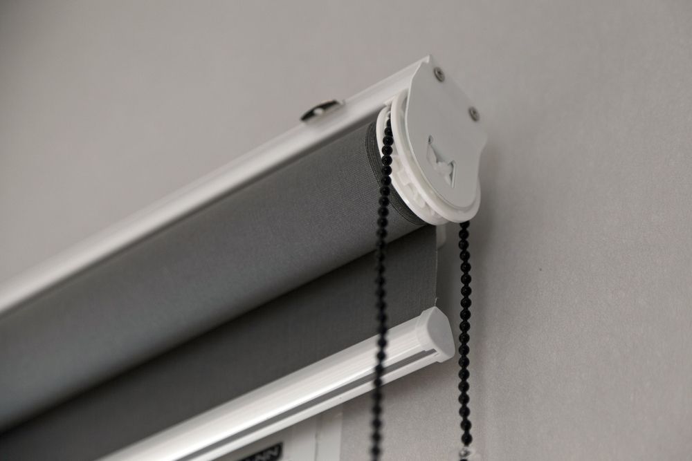 A Close Up of a Roller Blind With Chains Attached to It — Curtain Haven & Blinds in Laurieton, NSW