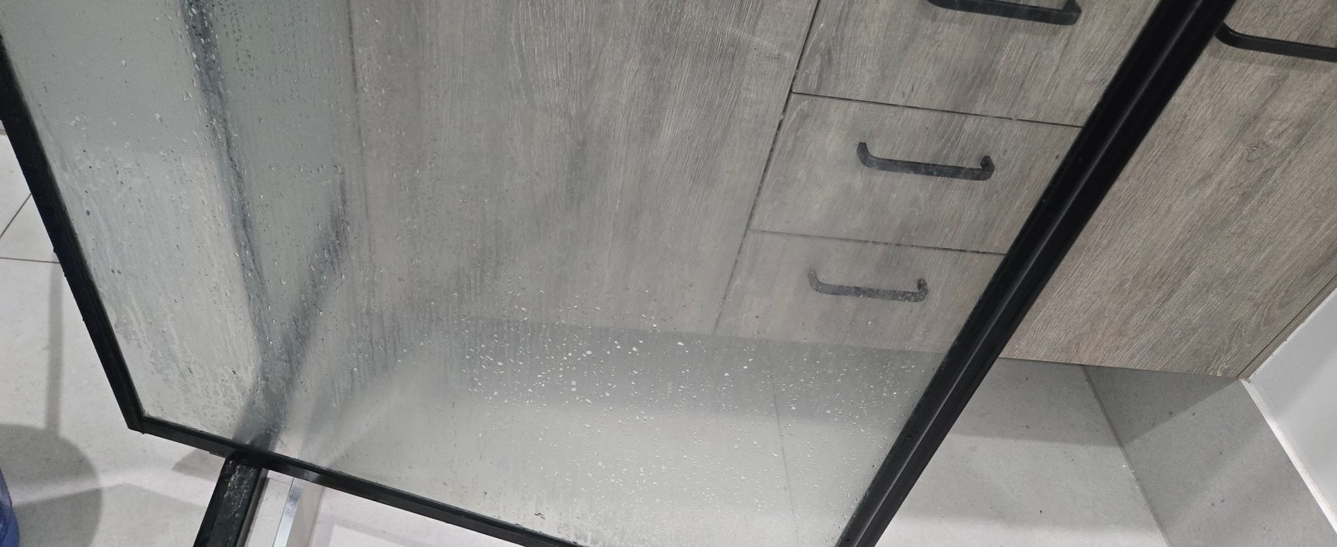 Dirty calcified glass shower screen door
