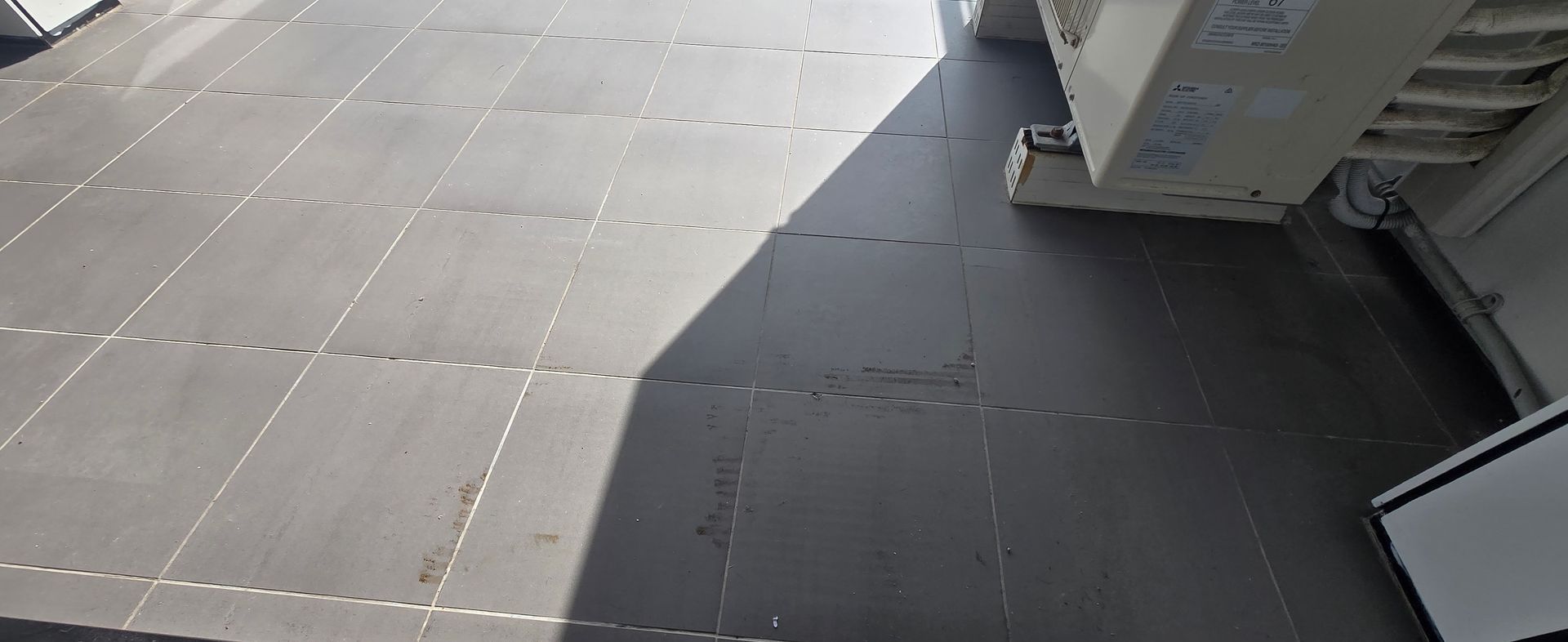 Tiled balcony with dirt and debris