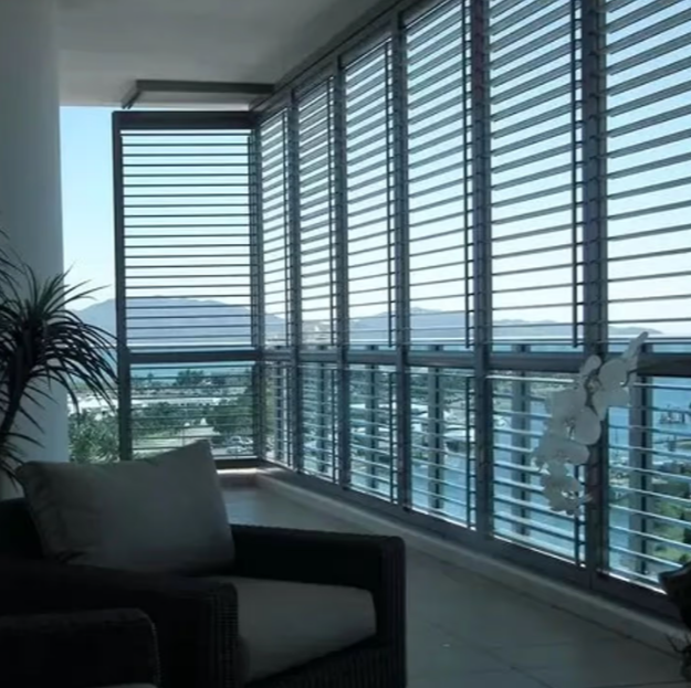 Modern living room with floor-to-ceiling blinds overlooking a city view