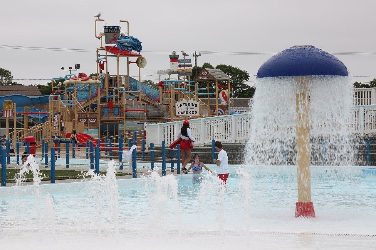 Water park with a large structure, fountain, and children playing.