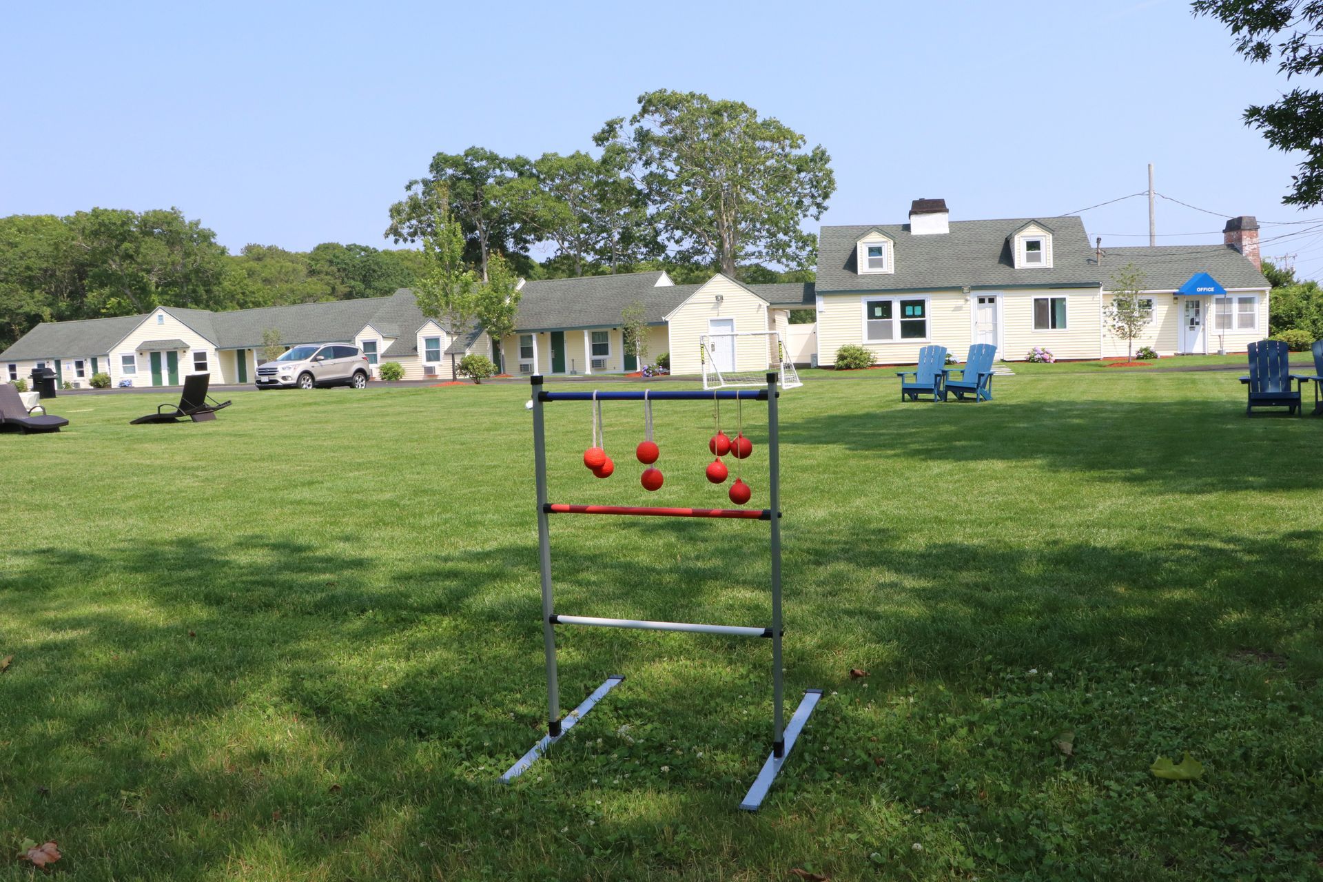 Ladder toss game on a grassy lawn with houses in the background on a sunny day.