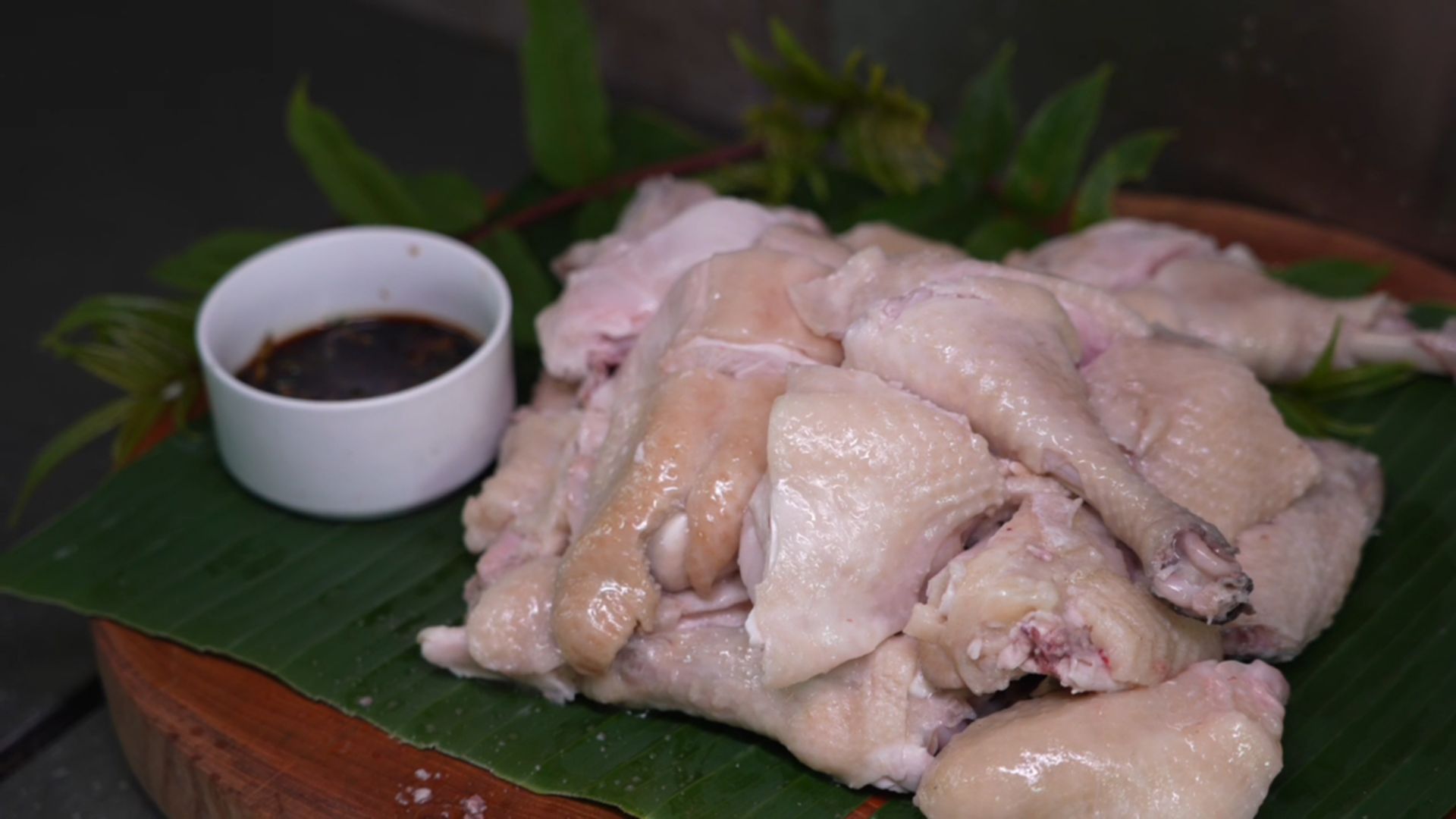中興紅羽1982土雞肉放在香蕉葉上,配上一小杯沾醬。