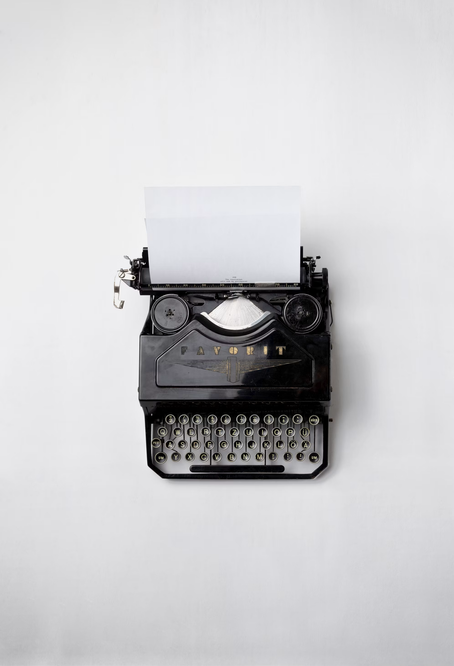 Vintage zwarte typemachine met papier op een witte achtergrond