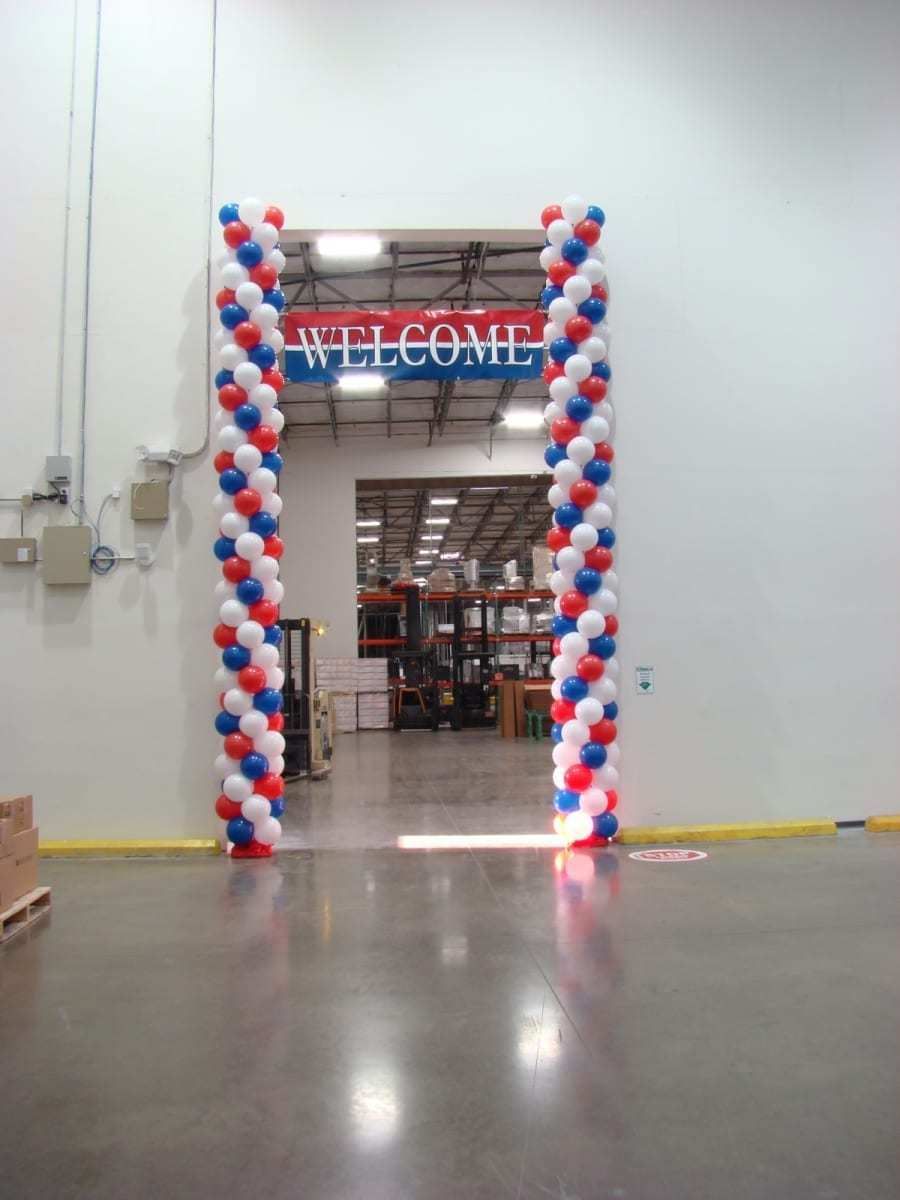 Tall red white and blue balloon columns framing a warehouse doorway