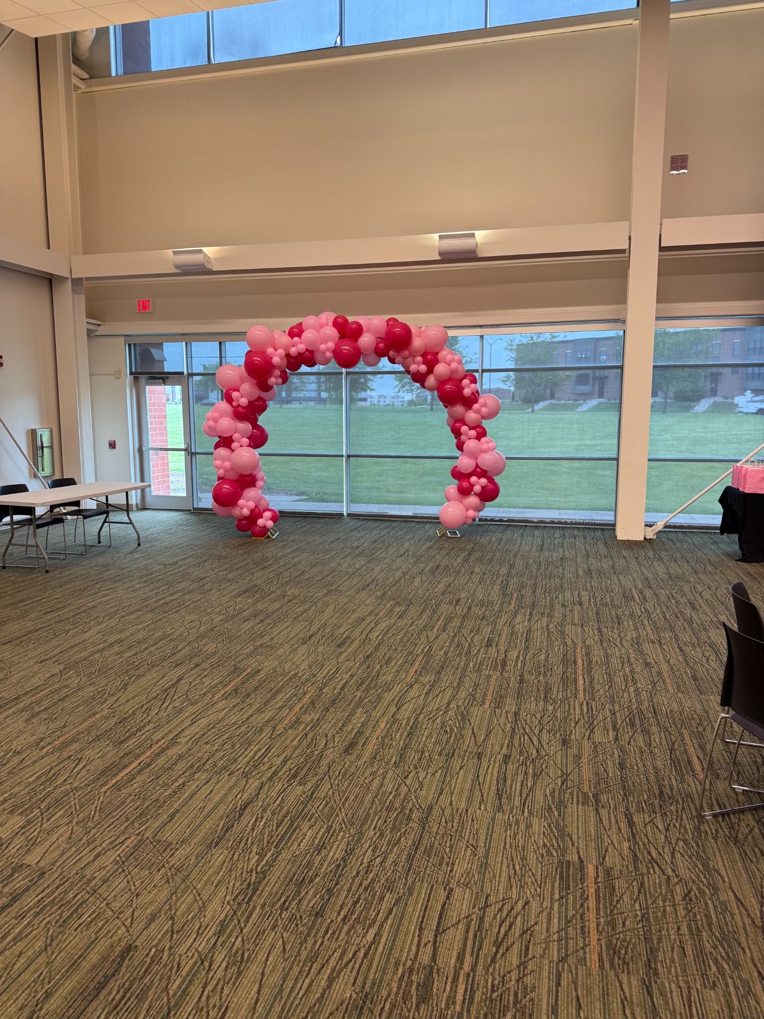 Pink organic balloon arch in a bright event venue