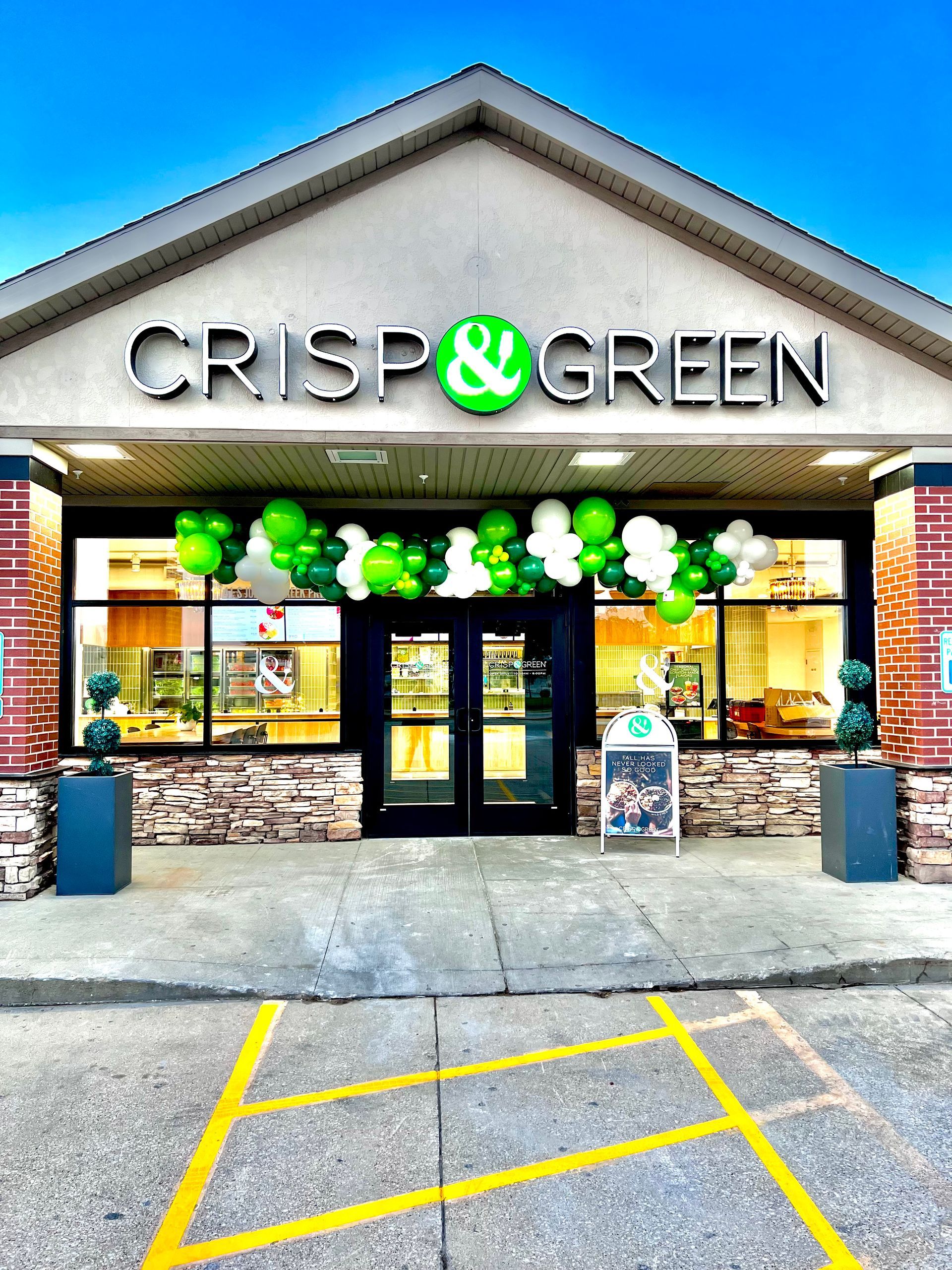 CRISP & GREEN restaurant entrance with green and white balloon decor by Squeak Balloon & Decor.