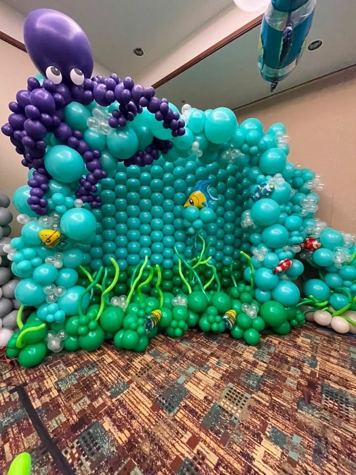 Underwater balloon sculpture scene with teal sea creatures and a purple octopus