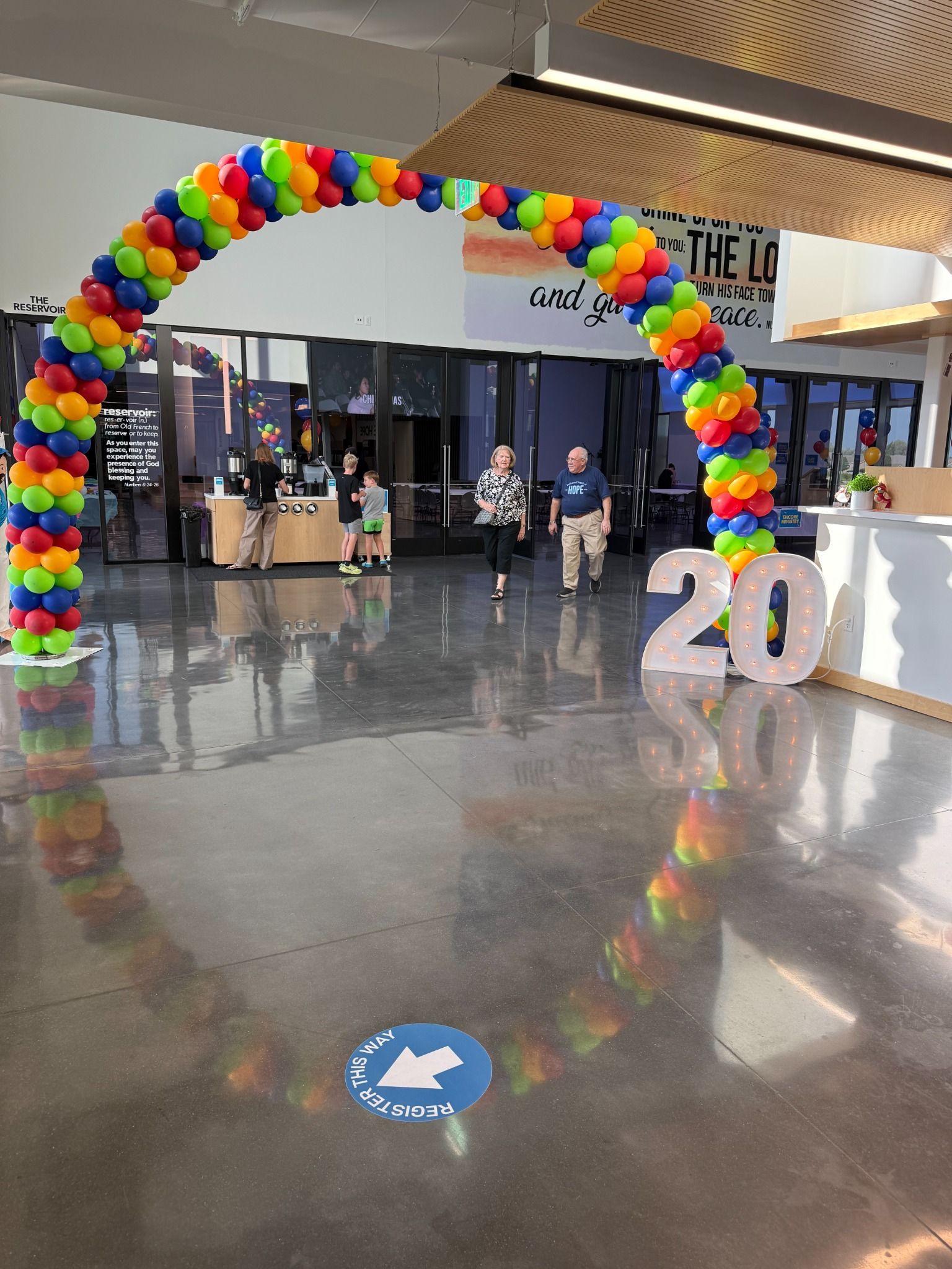 Rainbow balloon arch spanning an indoor event entrance