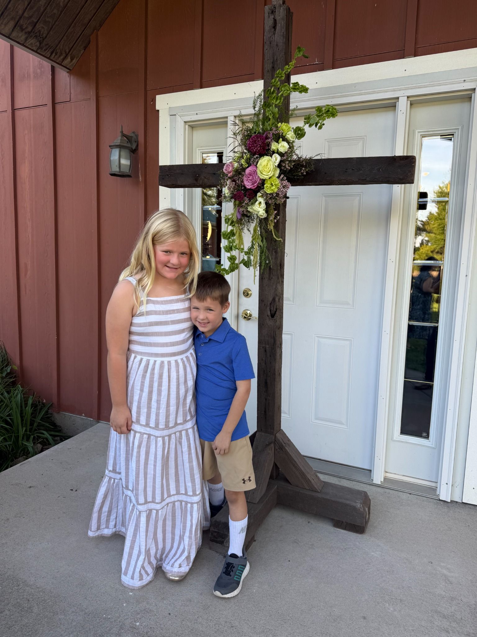 Hadley and Hudson beside a floral cross