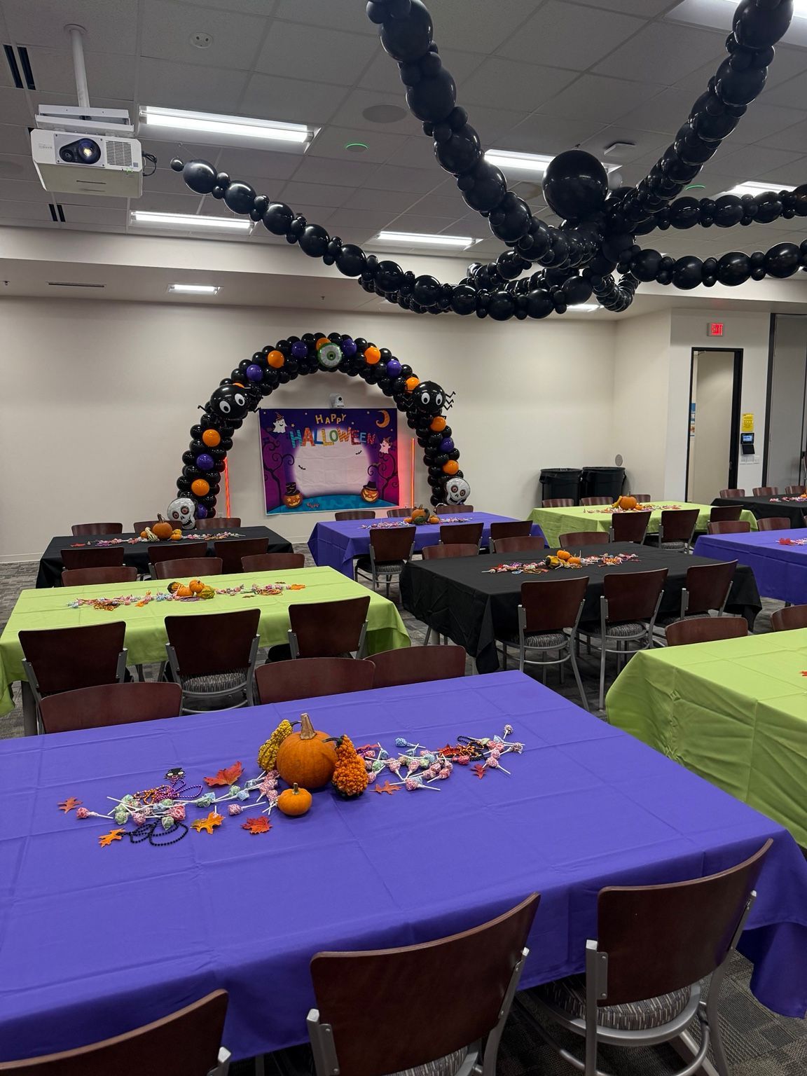 Halloween balloon arch beneath the giant suspended balloon spider at Sysco Iowa