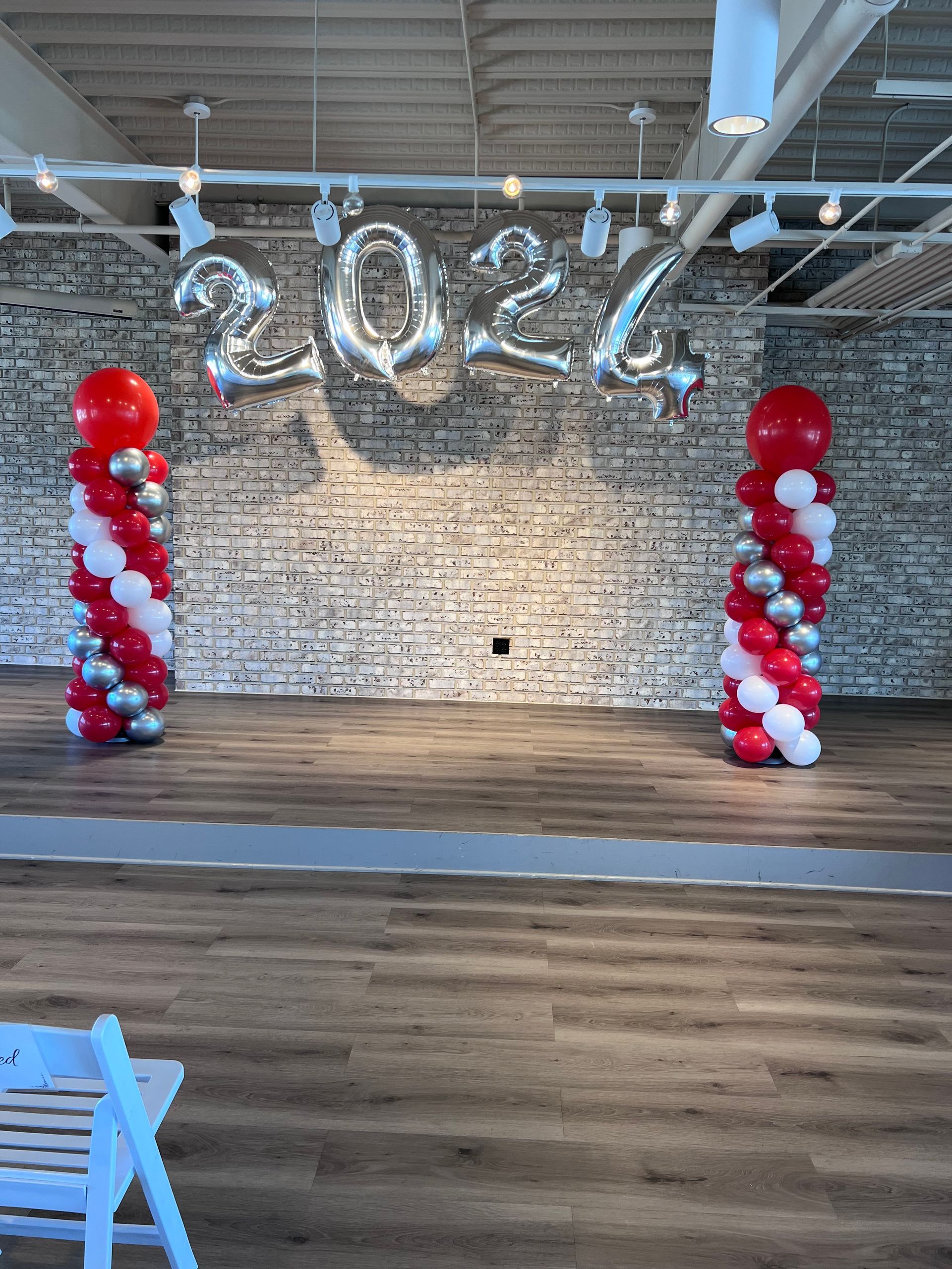 Red and white classic spiral balloon columns framing an event backdrop