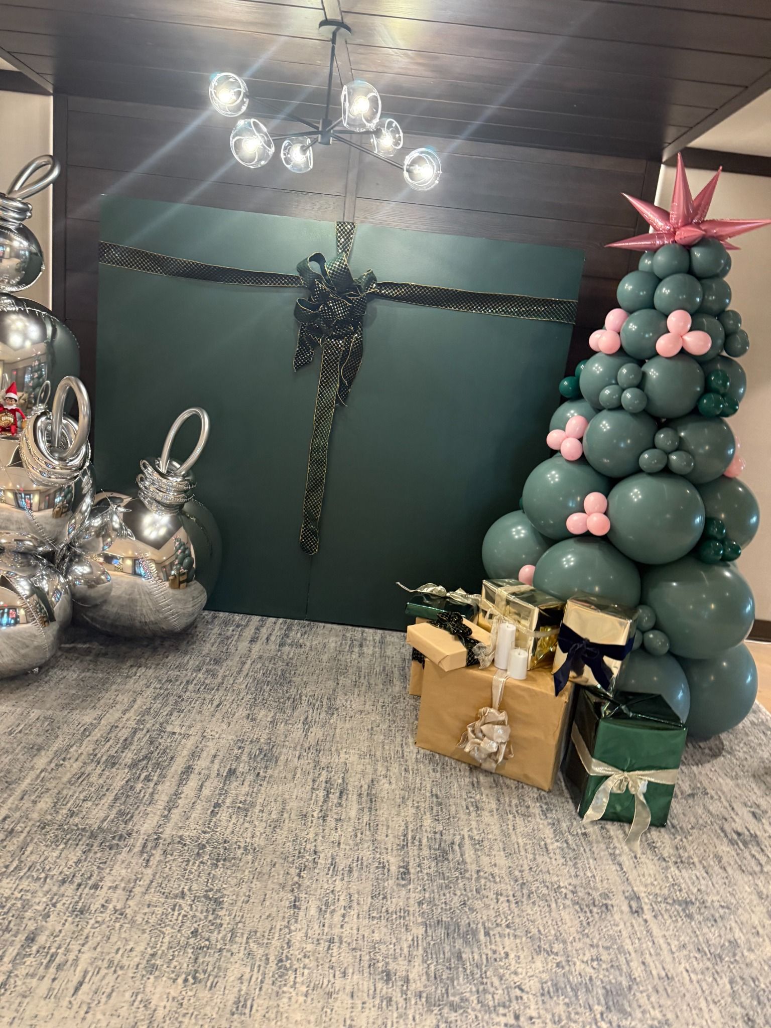 Balloon Christmas tree and festive accents beside a dark green backdrop