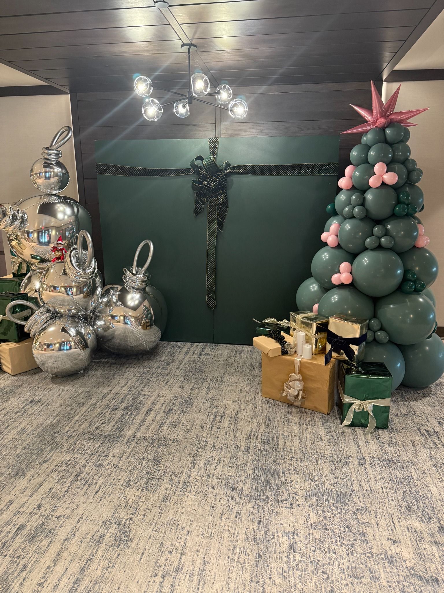 Green balloon Christmas tree with pink accents and wrapped presents