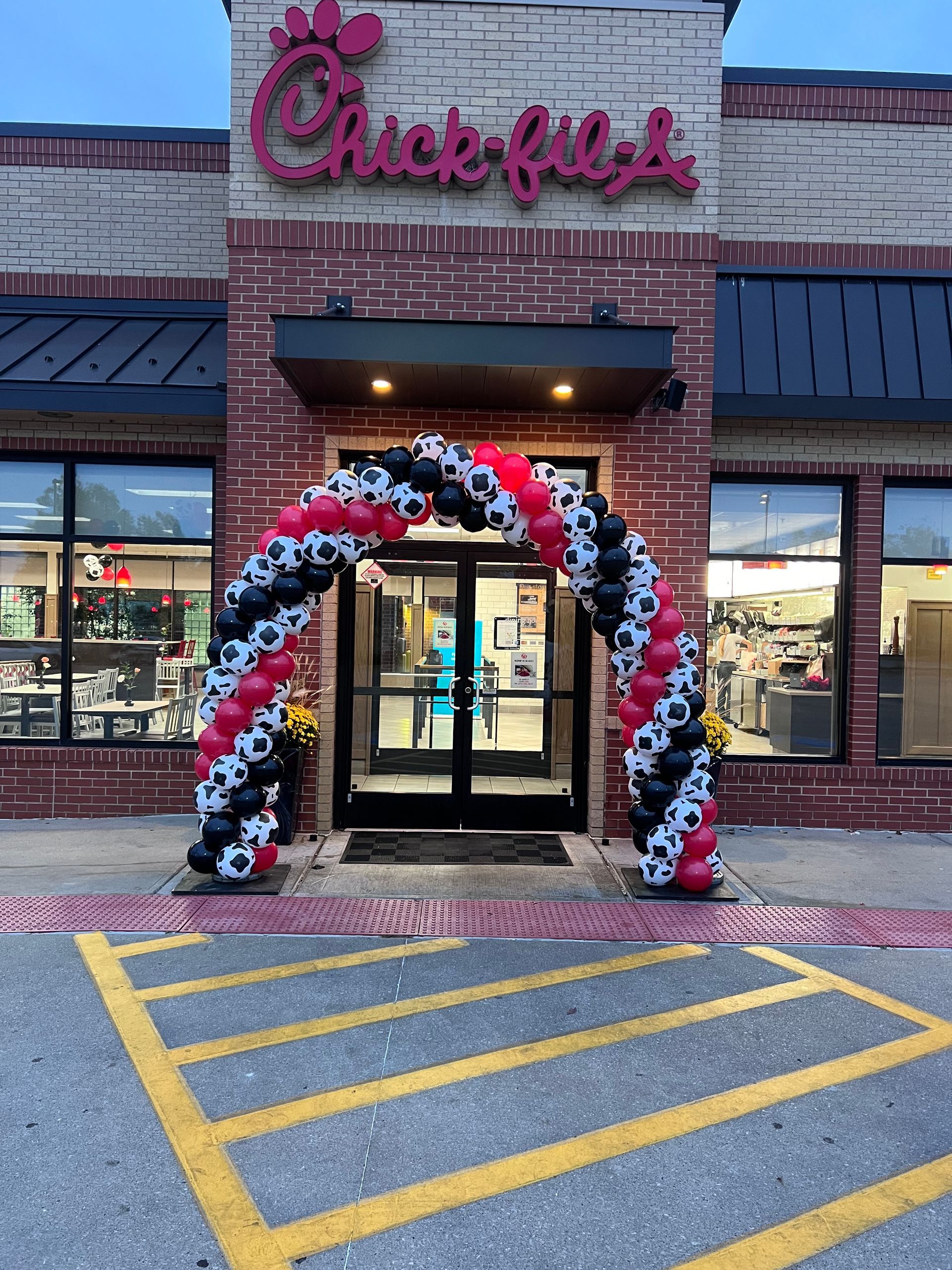 Red, white, and blue balloon arch framing a business entrance.
