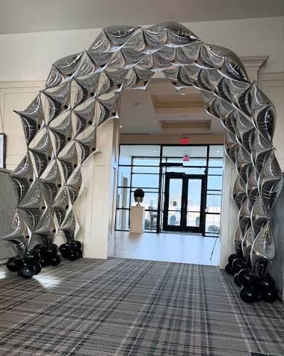 Metallic silver sculptural balloon arch with black balloon bases