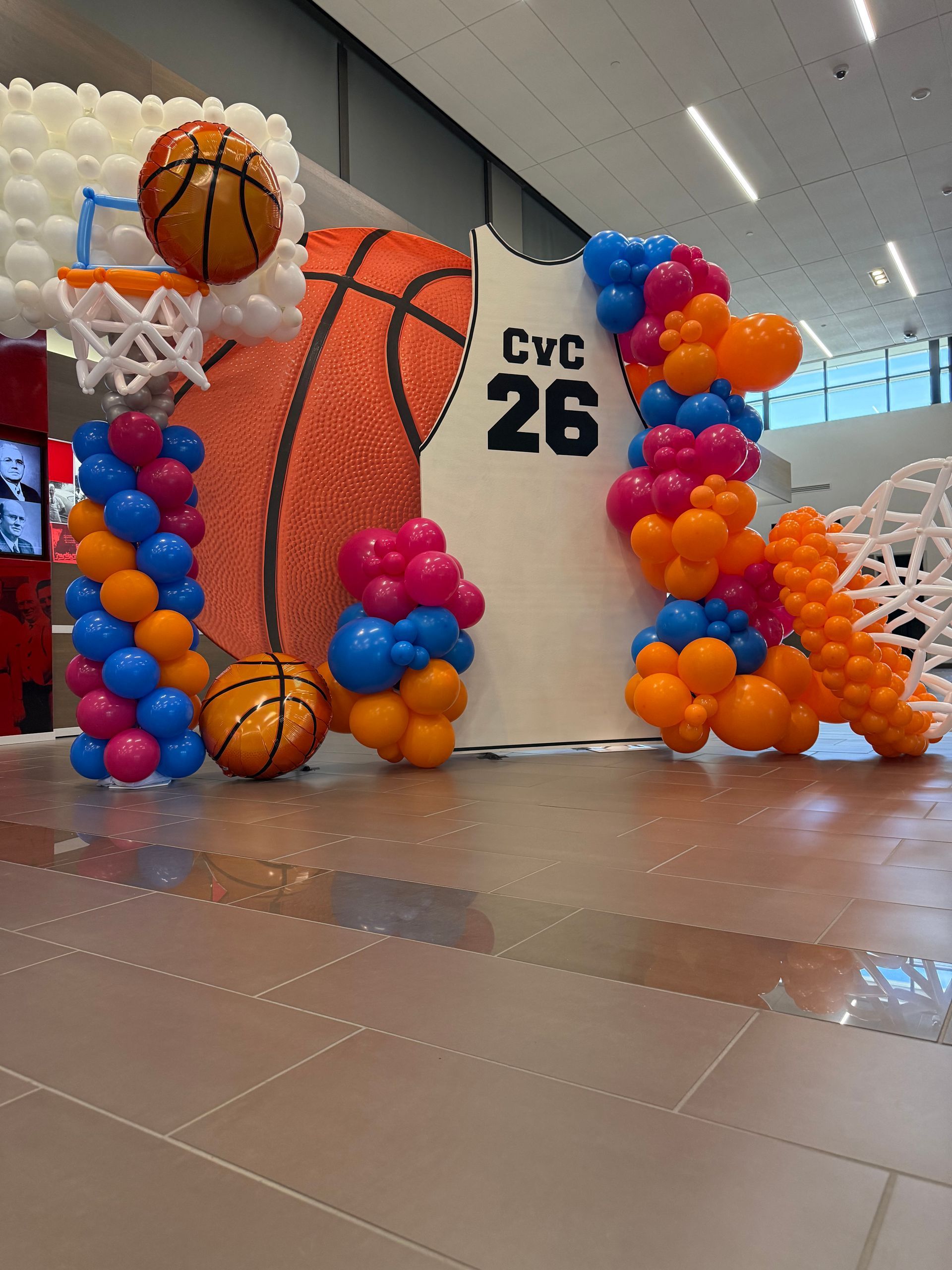 Colorful basketball-themed balloon display with “CYC 26” in a gymnasium hallway