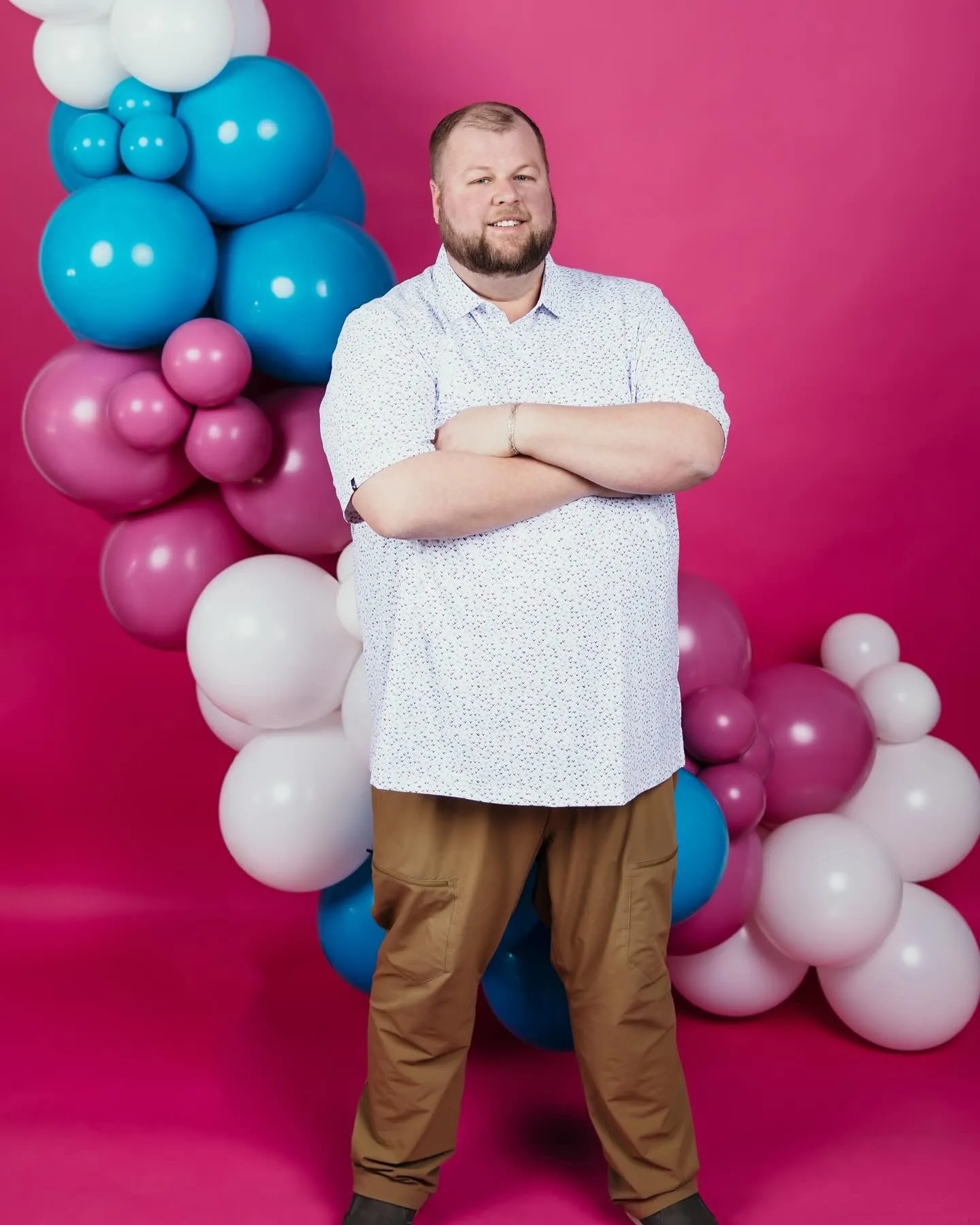 Travis Green of Squeak Balloon & Decor with pink, blue, and white balloons in Ankeny, Iowa.
