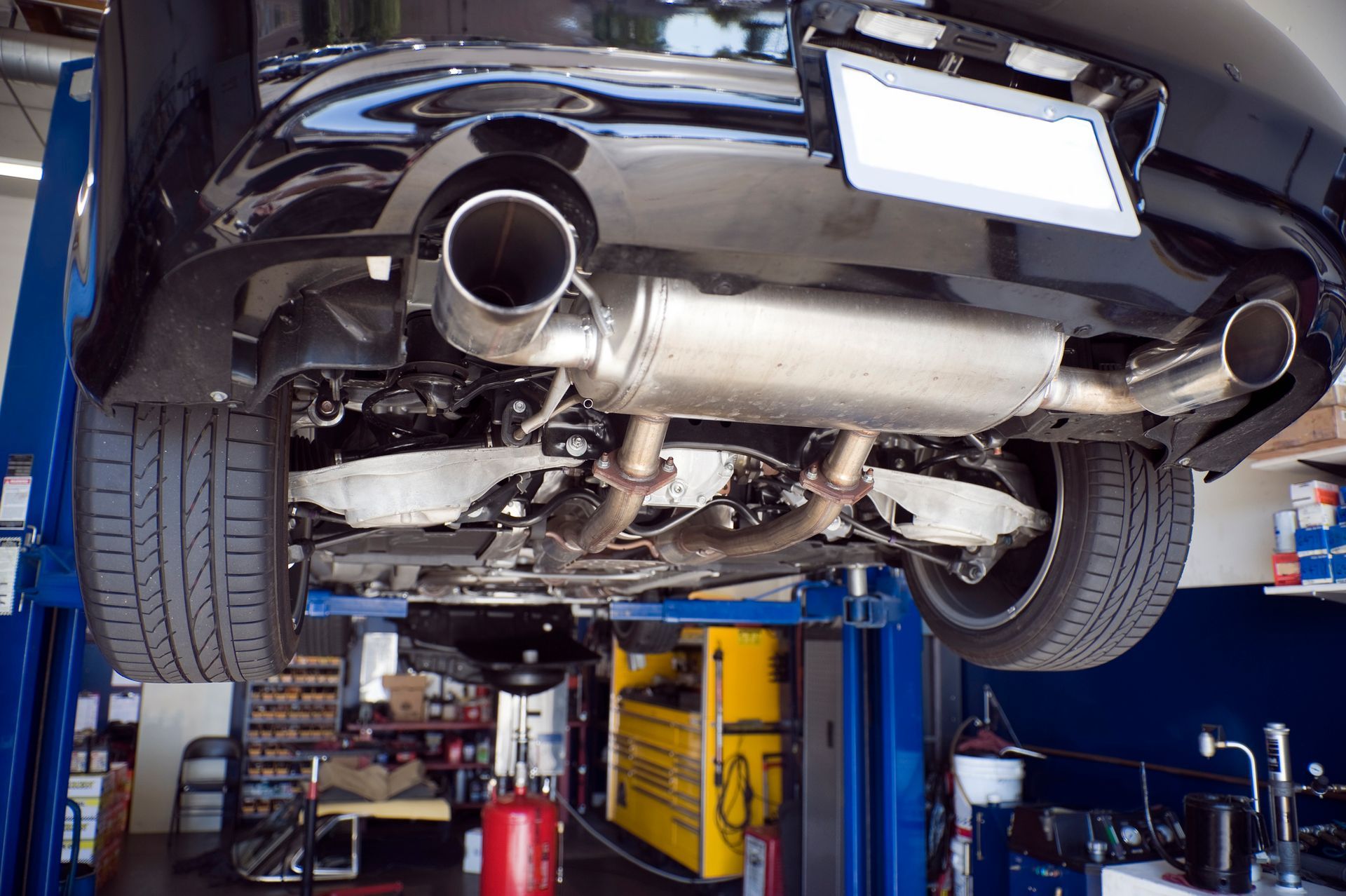 A car is sitting on a lift in a garage.