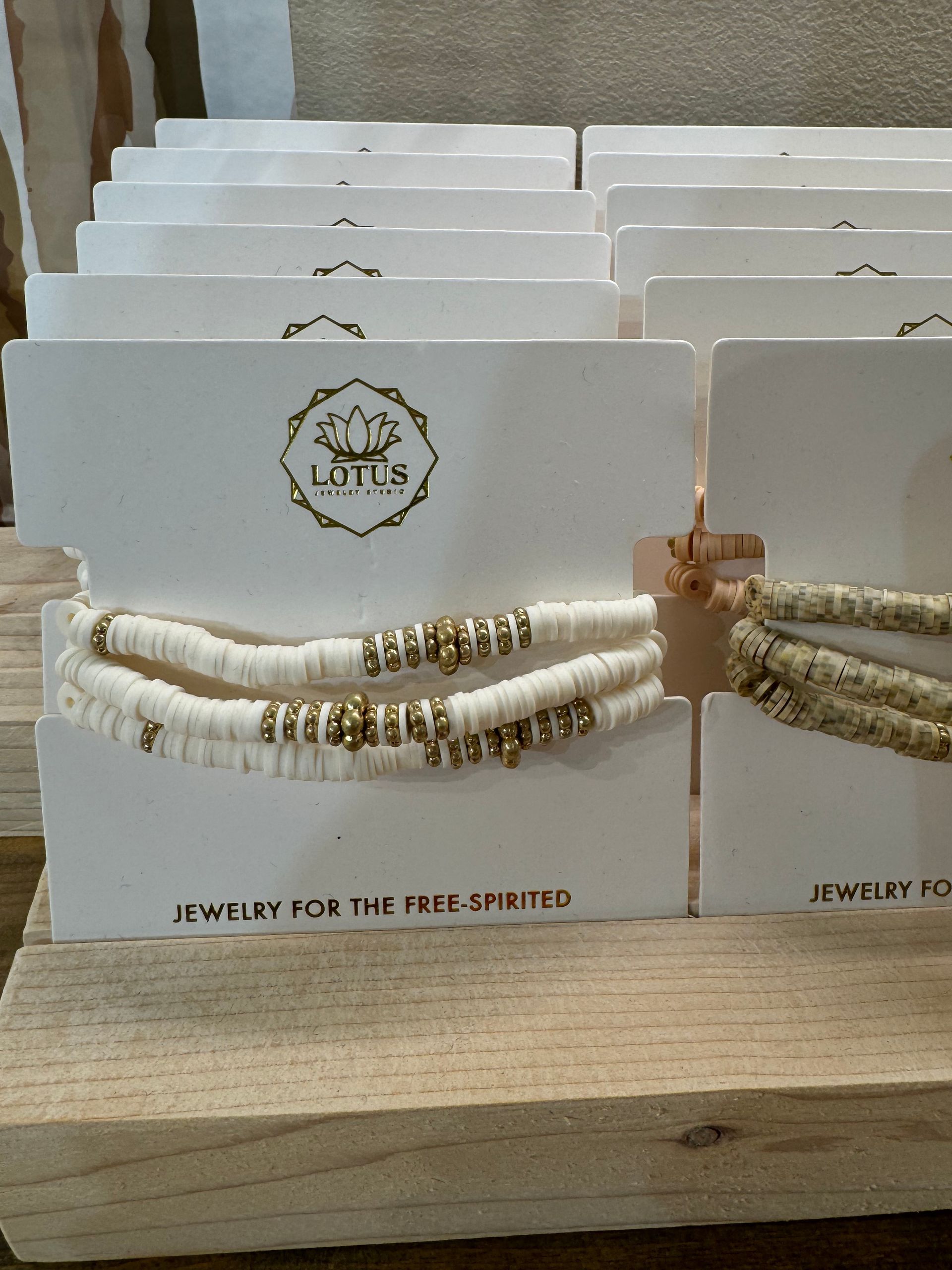 A stack of little jewelry cards on a wooden table