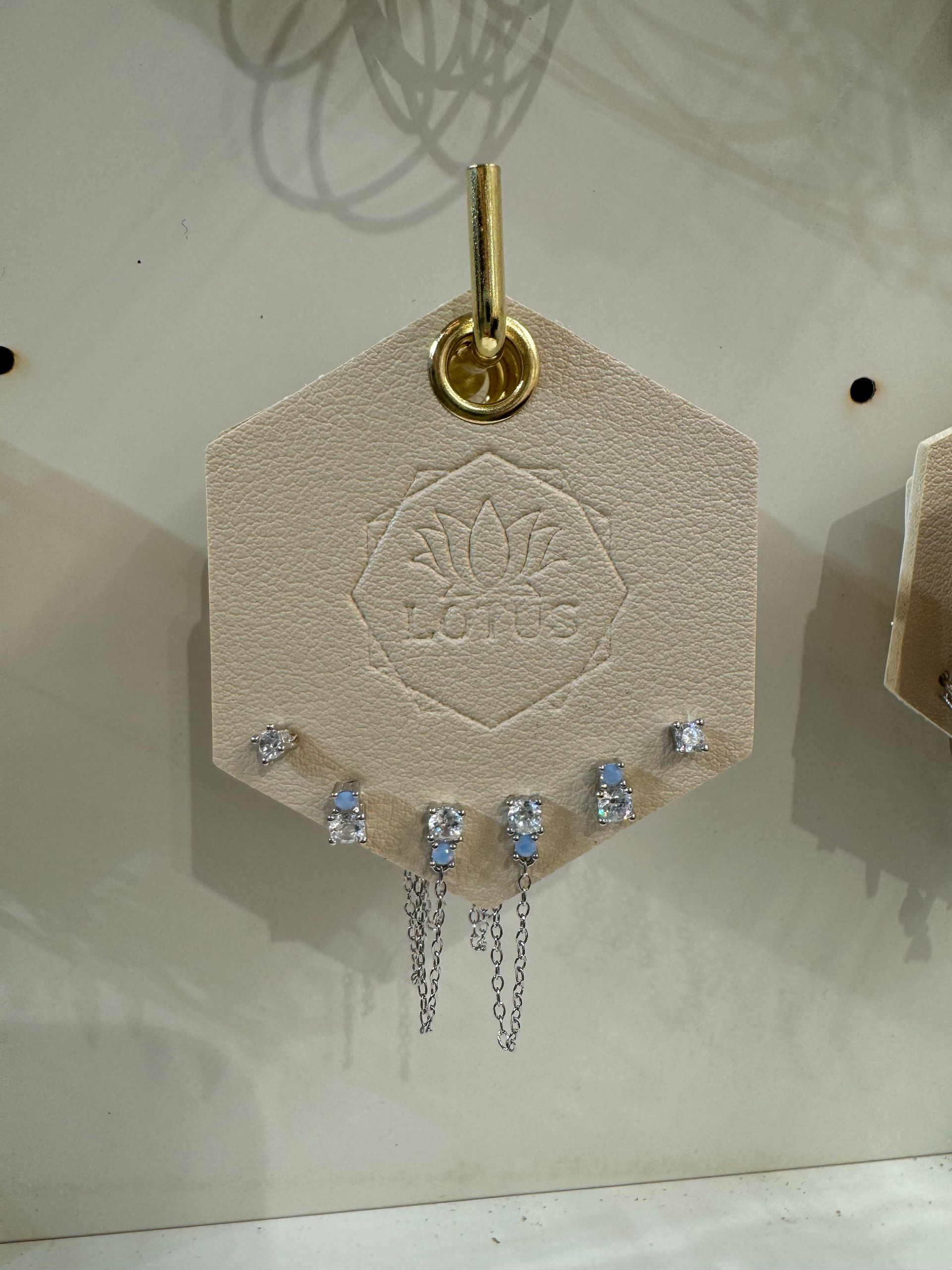 A pair of earrings hanging from a hook on a wall