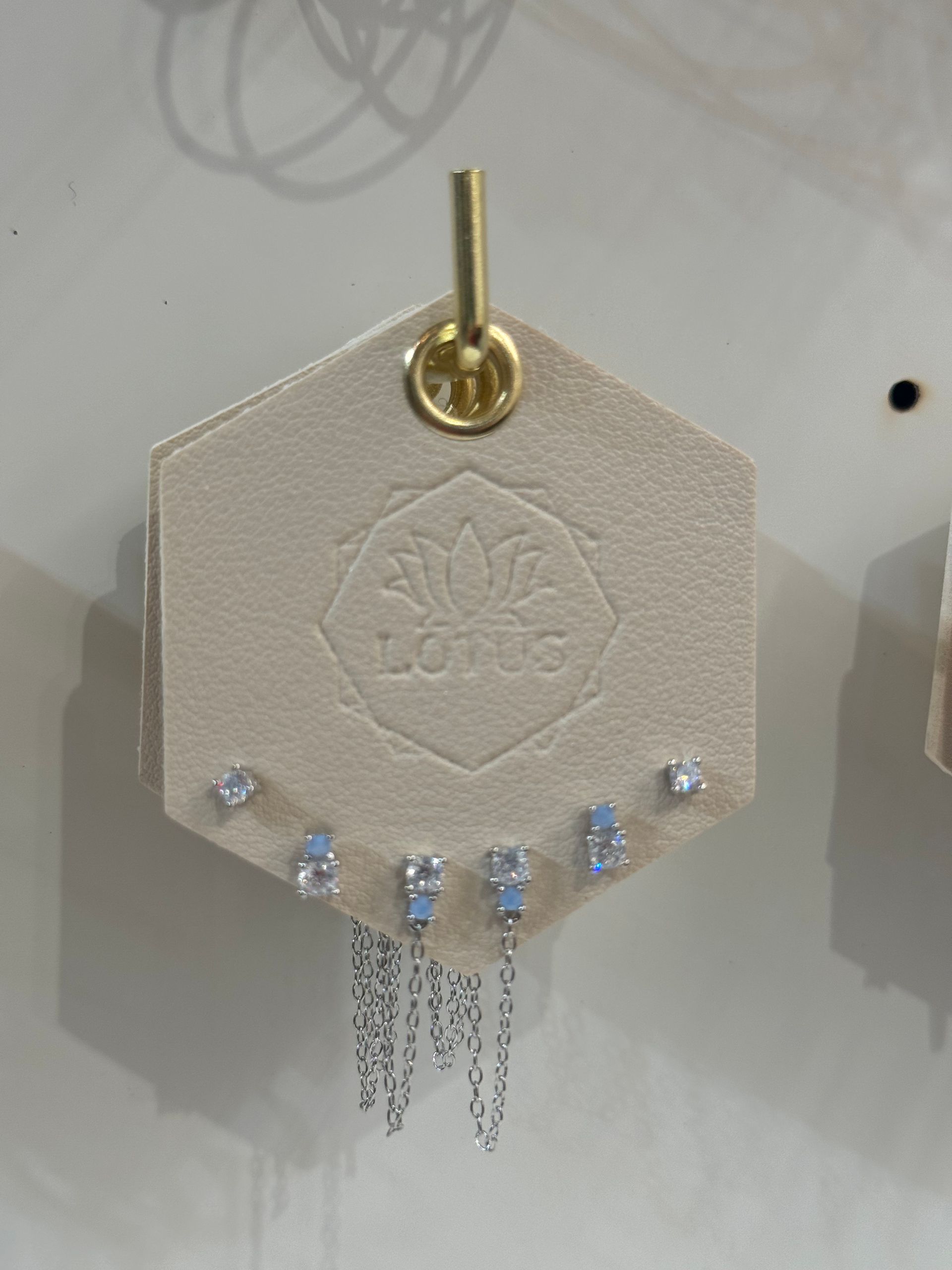 A pair of earrings are displayed on a card that says love