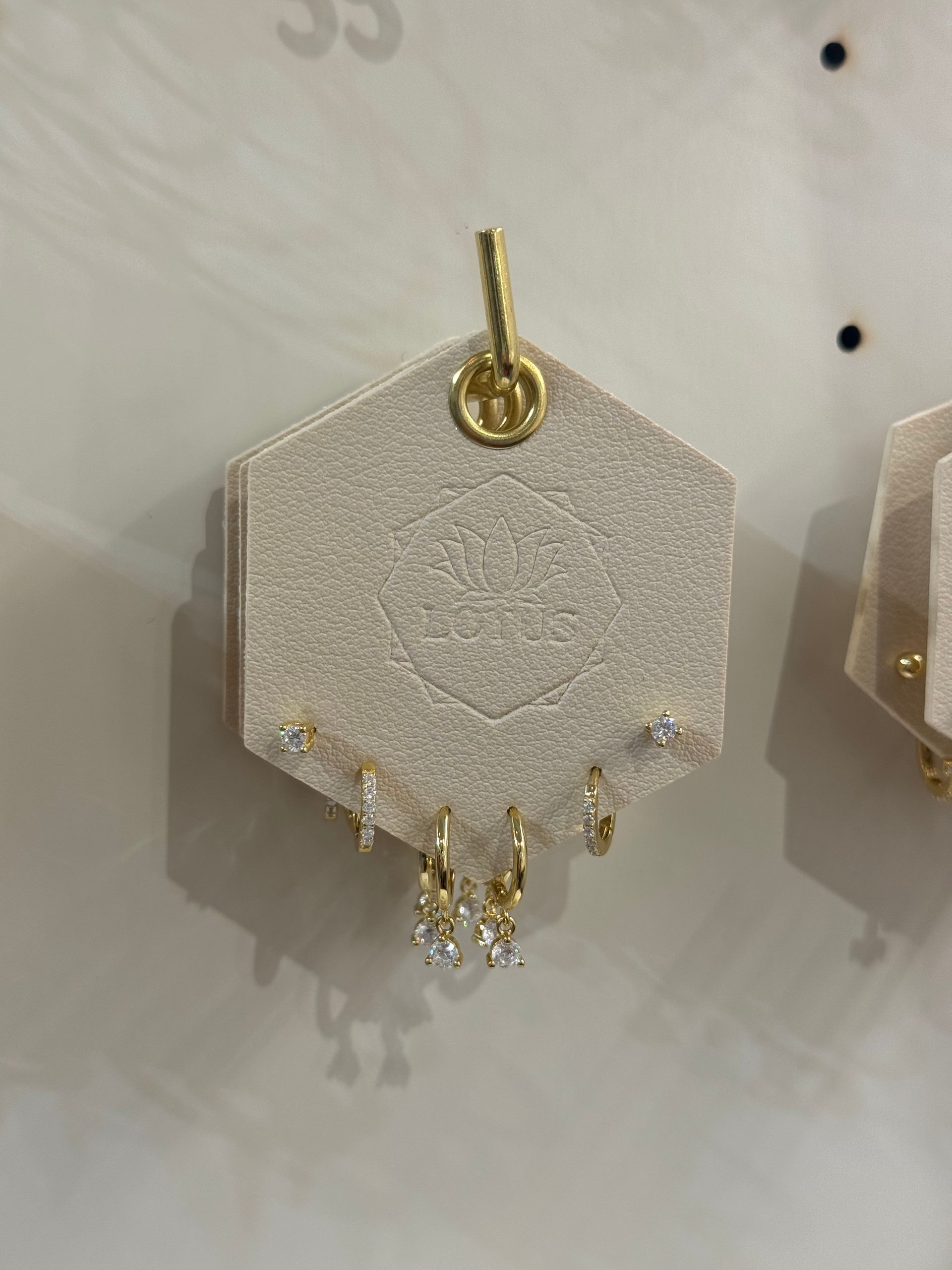 A pair of earrings are displayed on a white surface