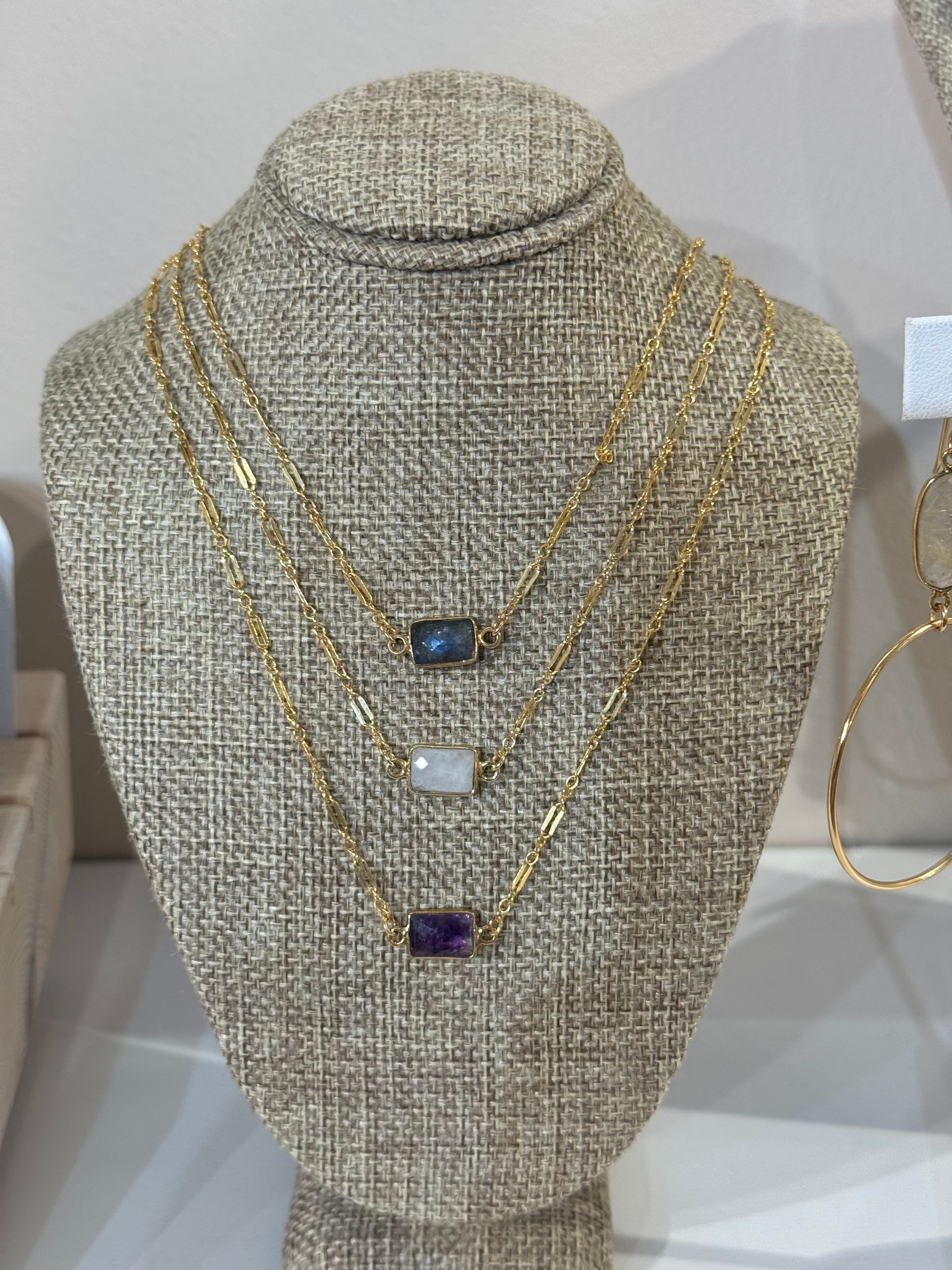 A mannequin with three necklaces on it