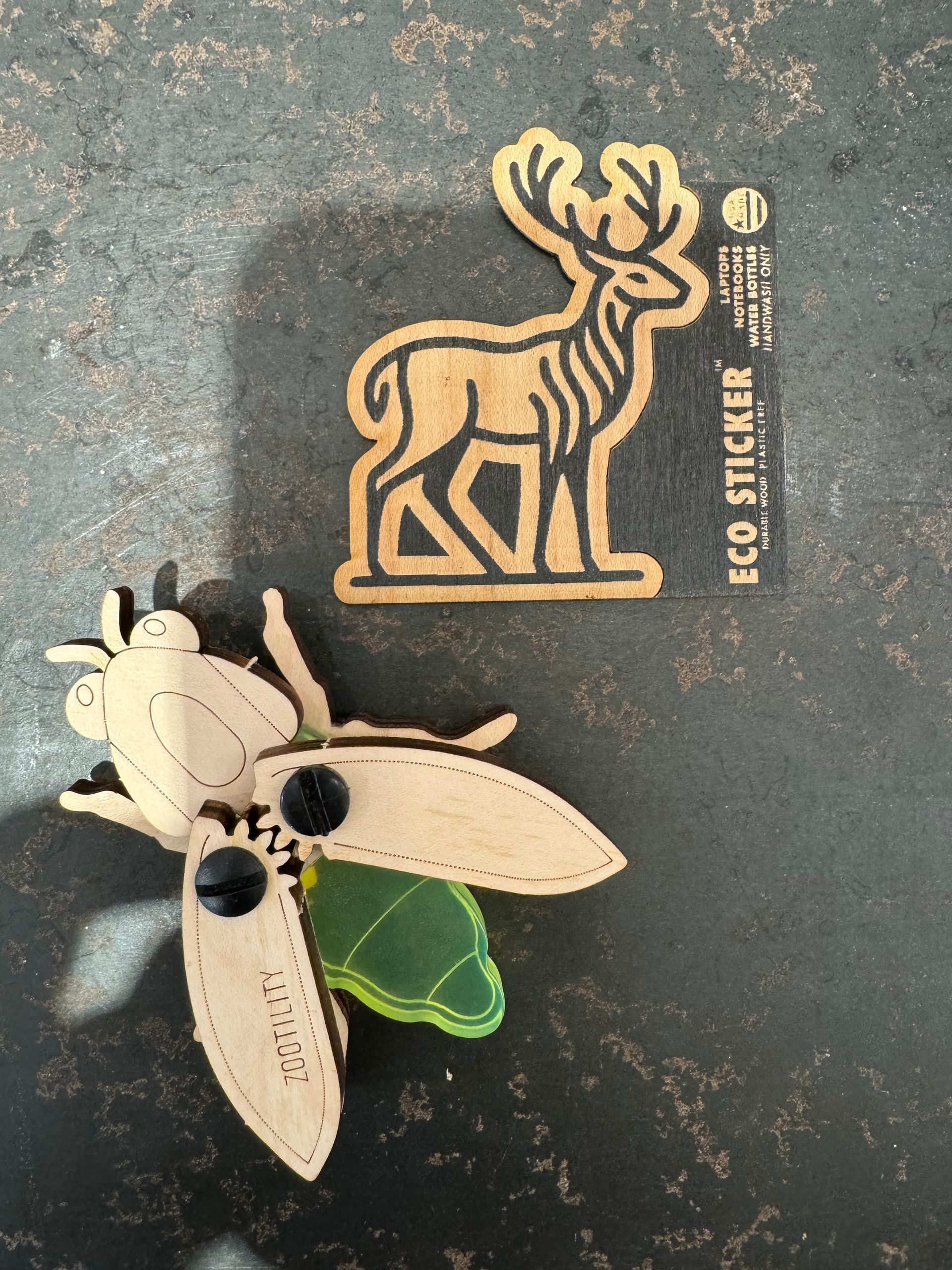 A wooden sticker of a deer and a fly