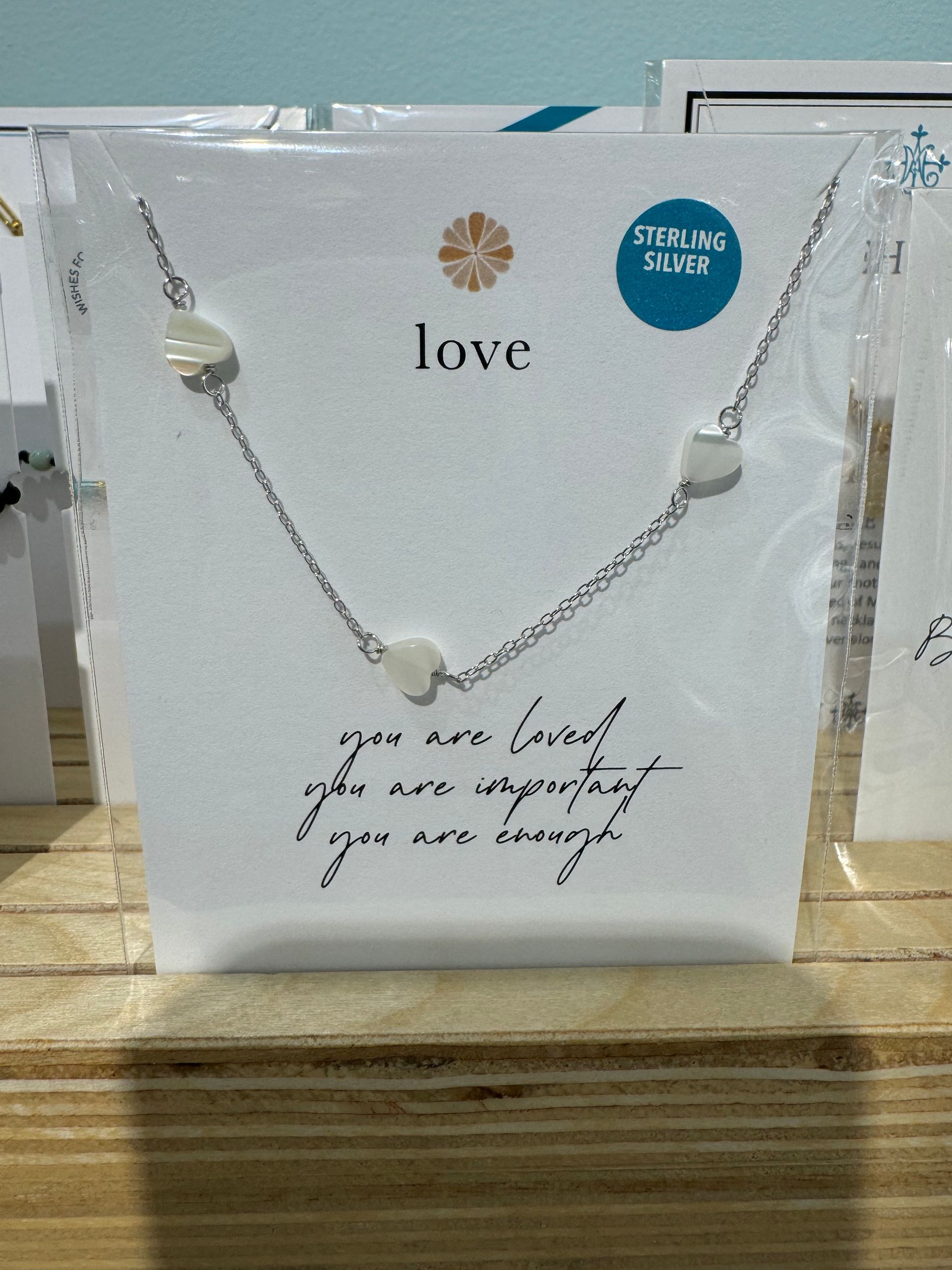 A necklace with a card that says love on it