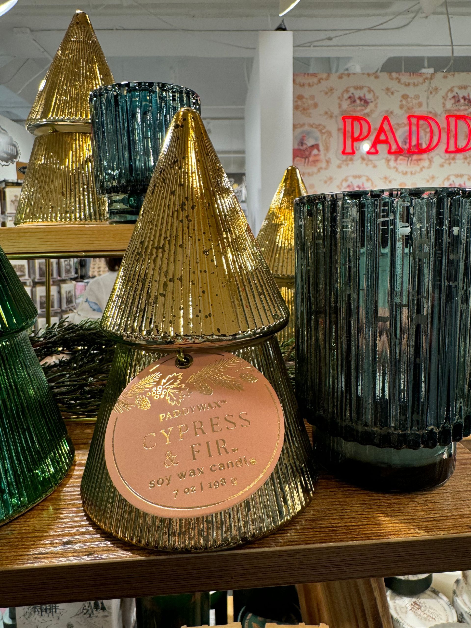 Several candles are on a shelf in front of a sign that says paddle