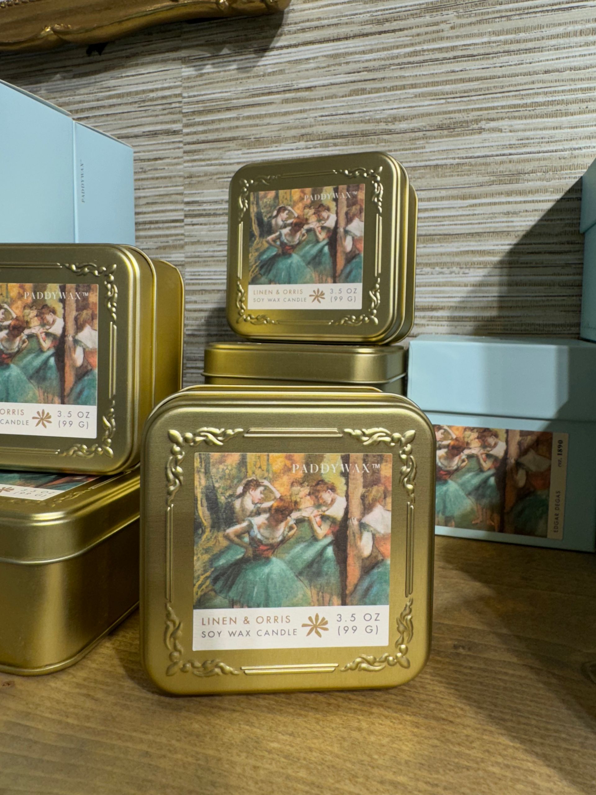 A stack of gold tins with paintings on them